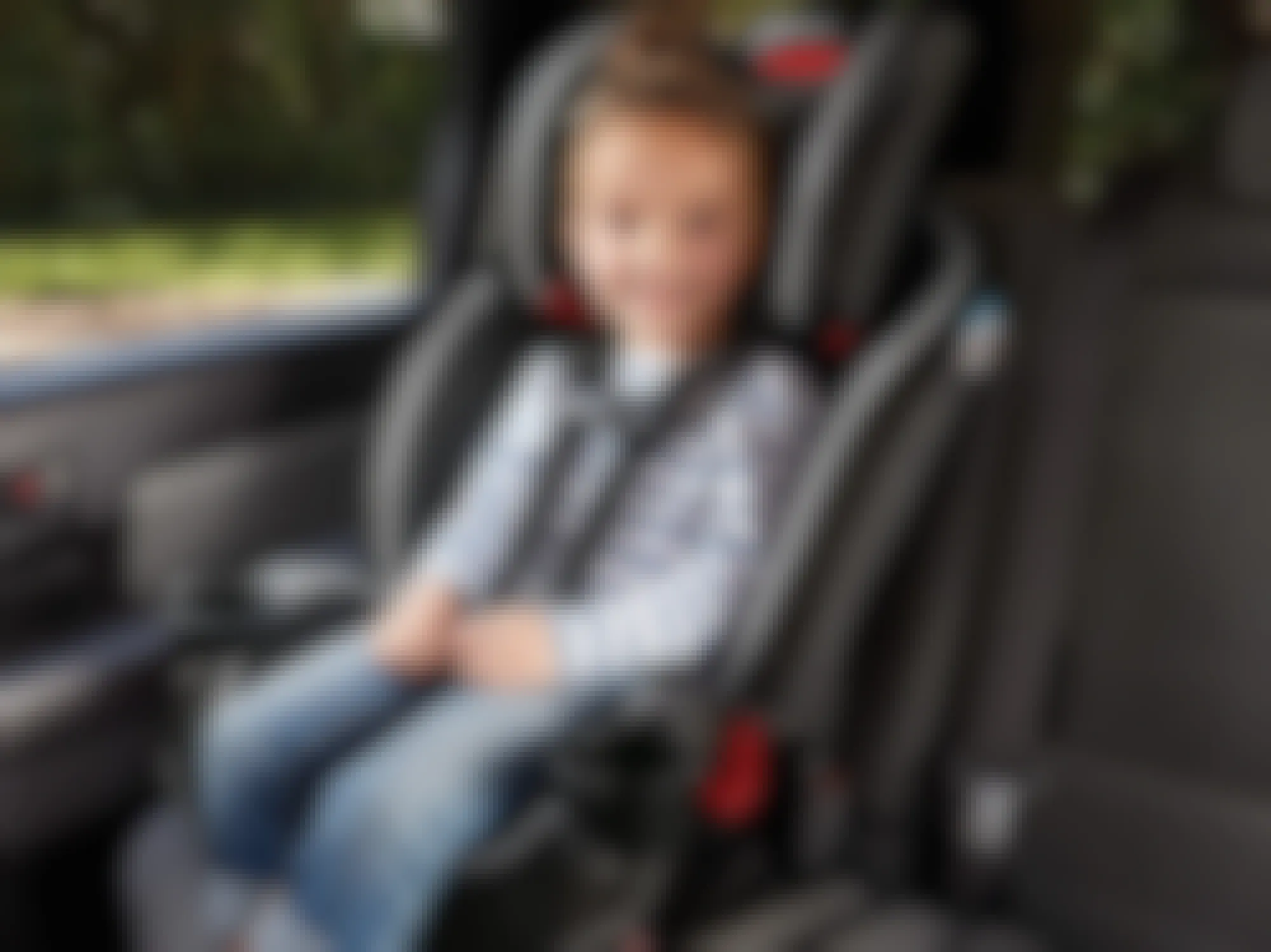 a child sitting in a graco slim fit car seat