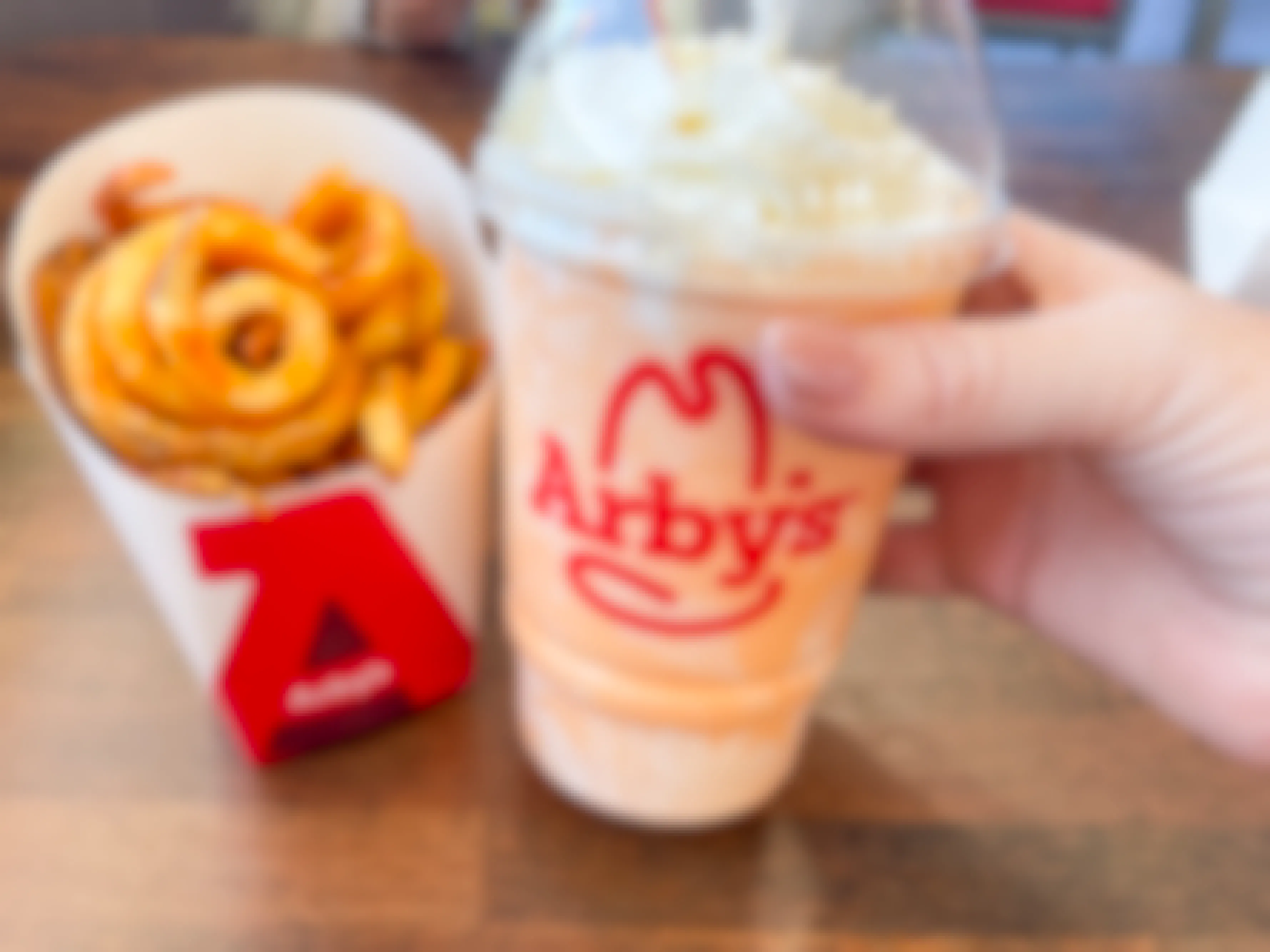 an arbys shake and curly fries on table 
