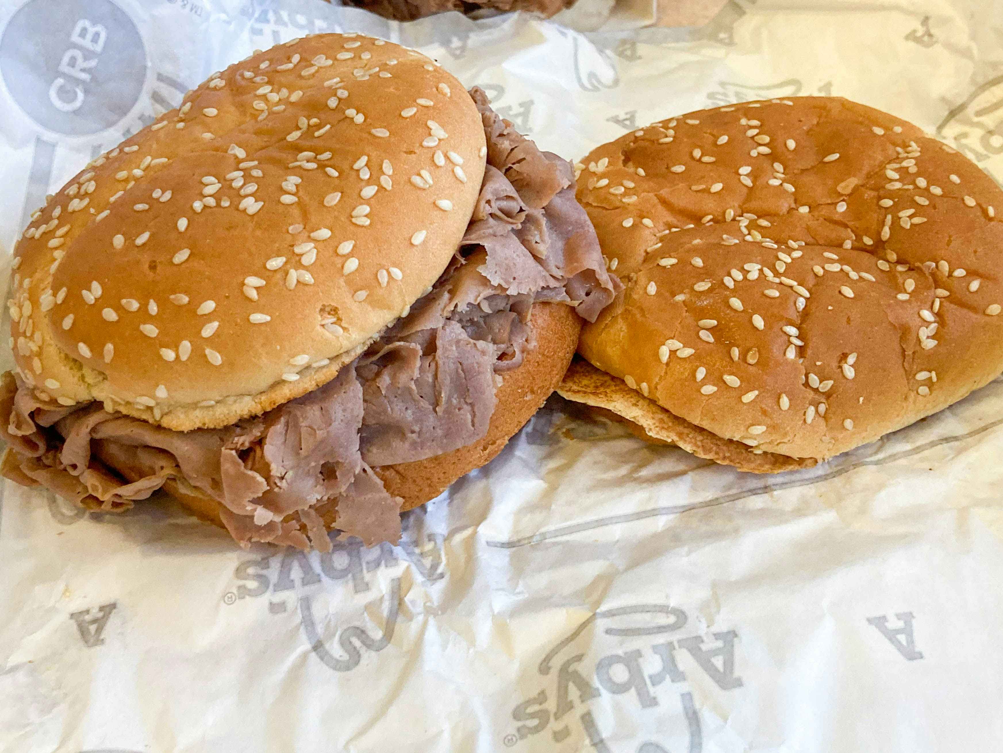 a classic roast beef sandwich wit next to an empty bun 