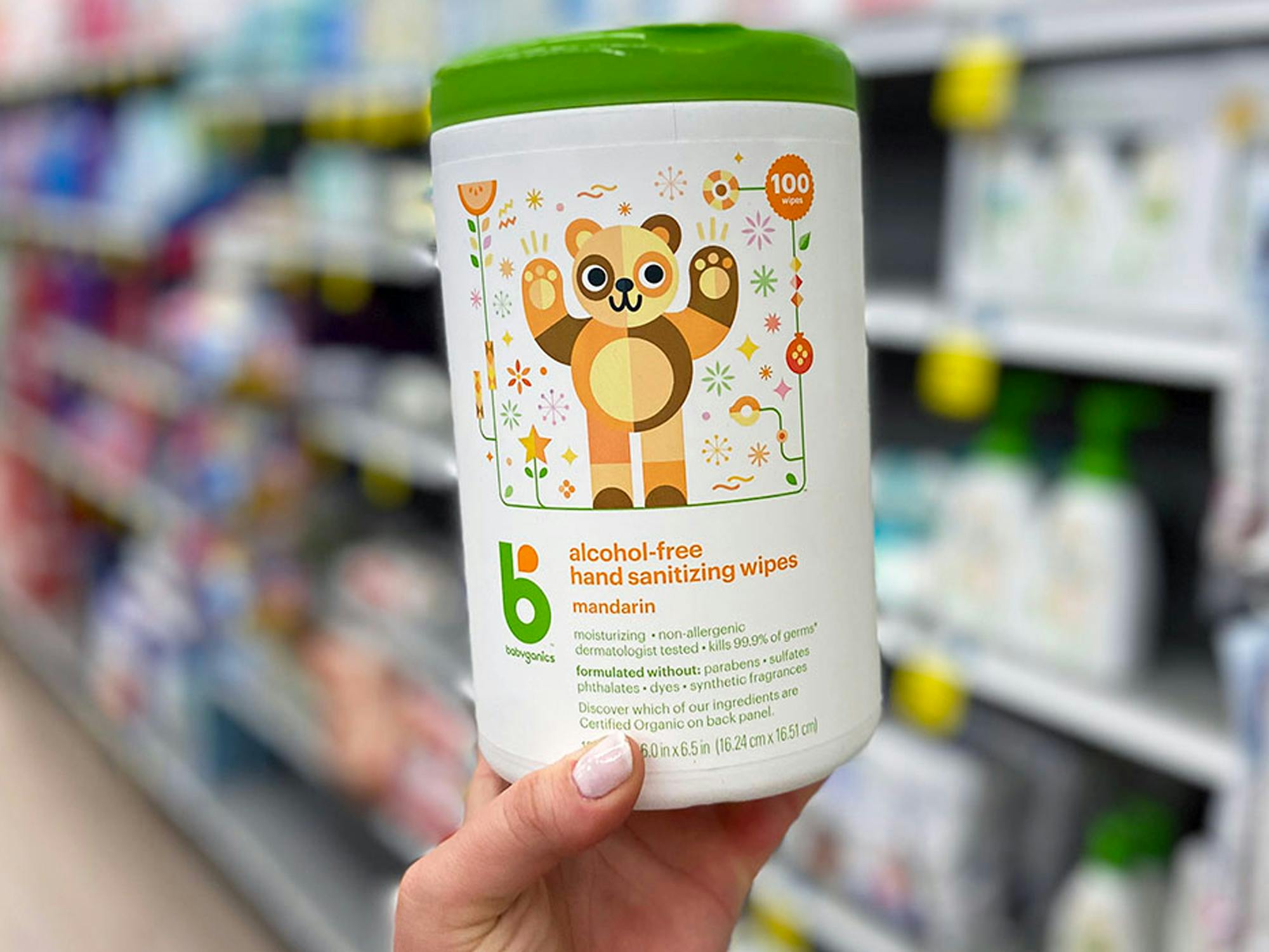 a person holding babyganics hand sanitizing wipes in a store