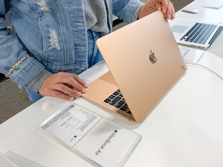 Someone looking at a Macbook Air at Best Buy
