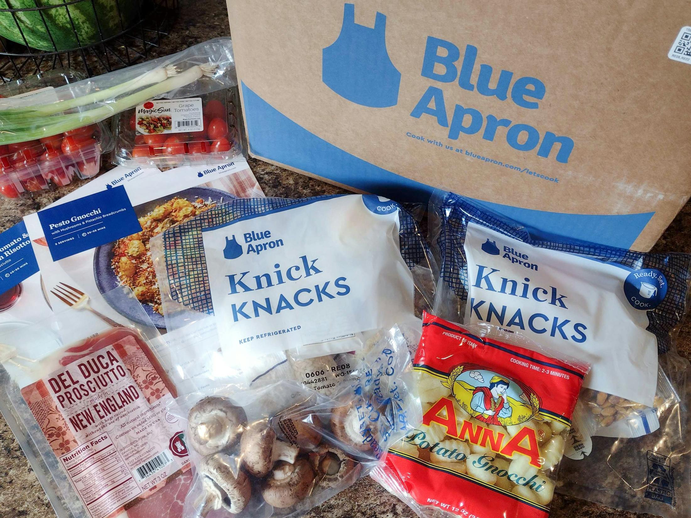 A Blue Apron box and its contents on a counter