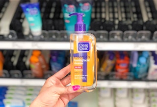 hand holding clean and clear face wash in front store shelf