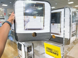 someone holding a white comforter in its package at jcpenney