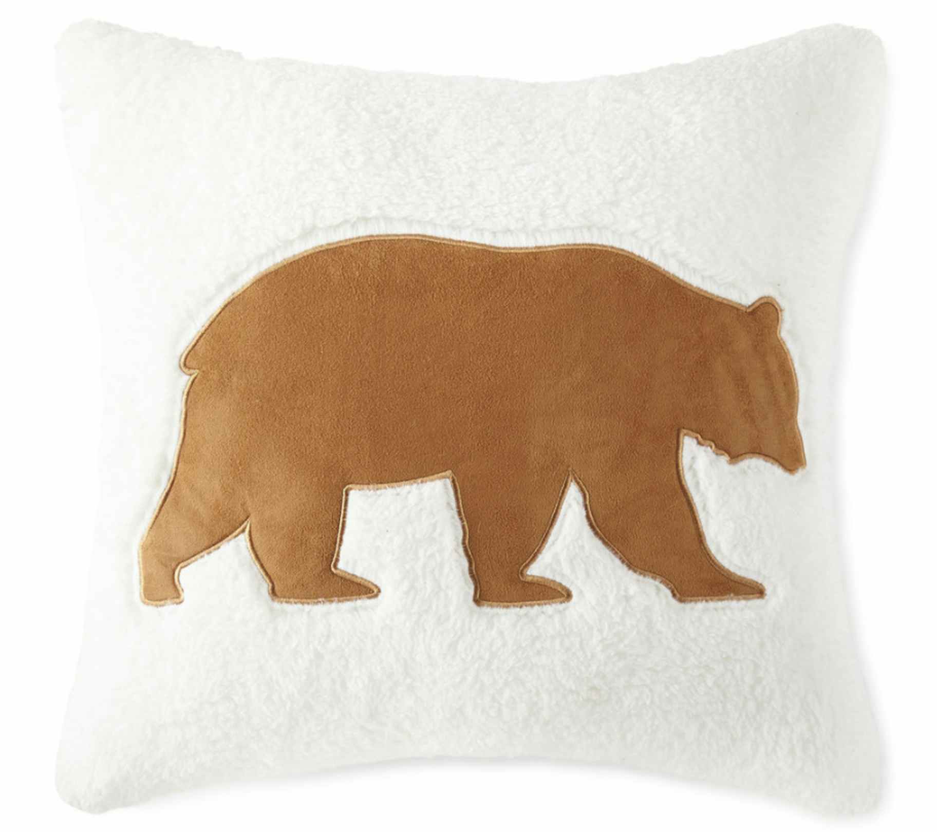 a white throw pillow with a bear
