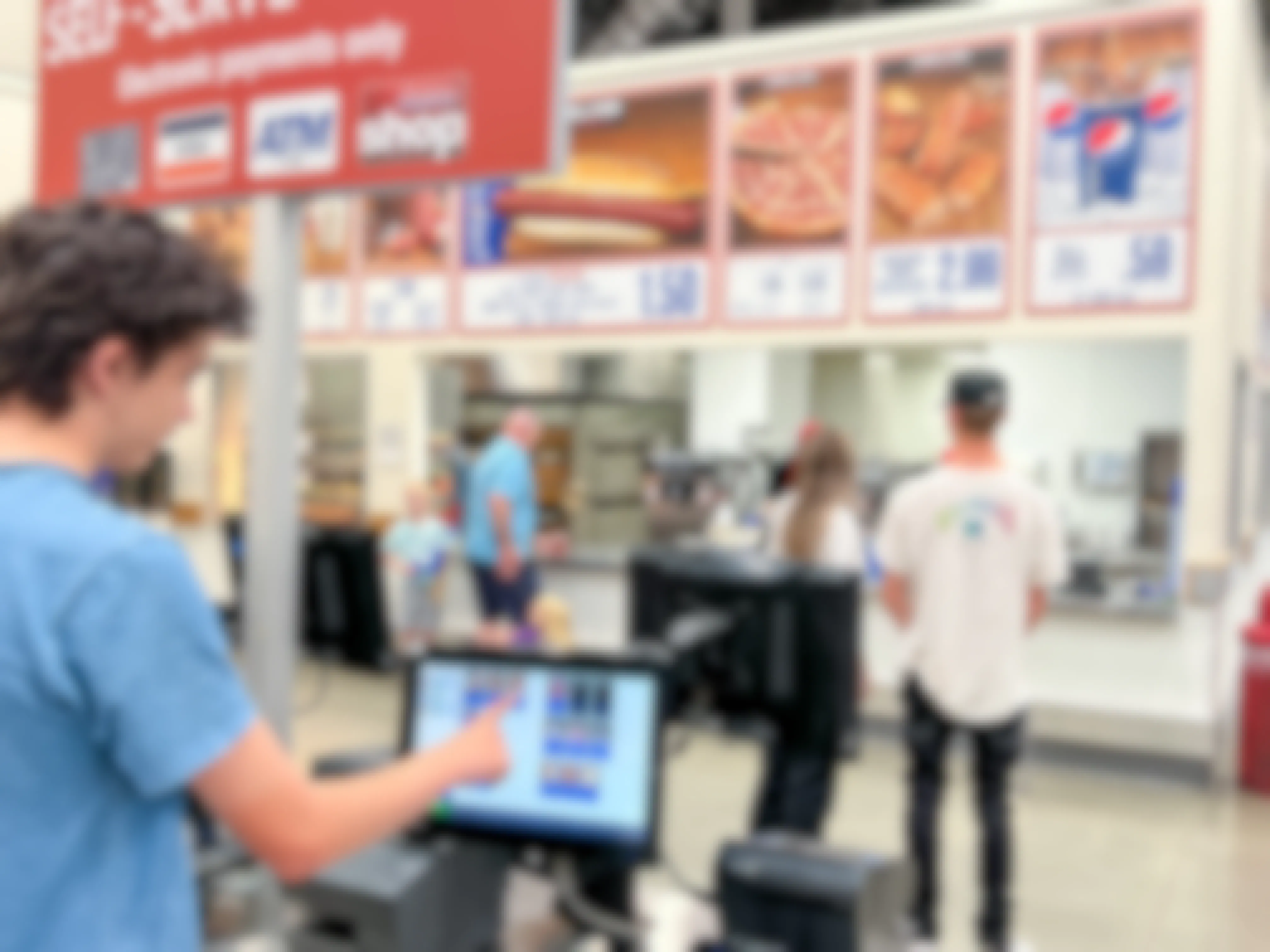 A teenager using the kiosk at the Costco food court to order some food.