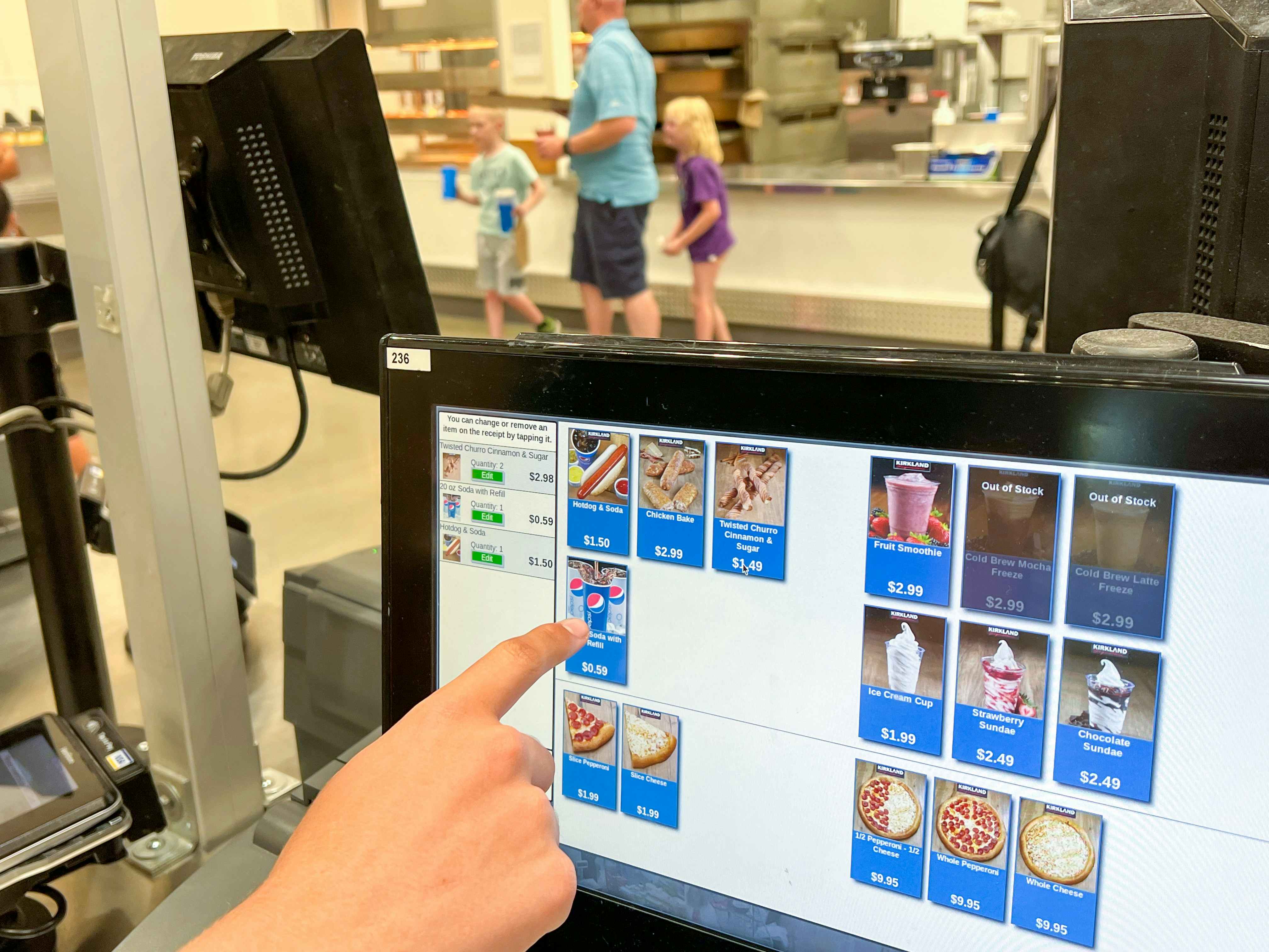 A person choosing items on the touchscreen at the Costco food court's self-serve kiosk.