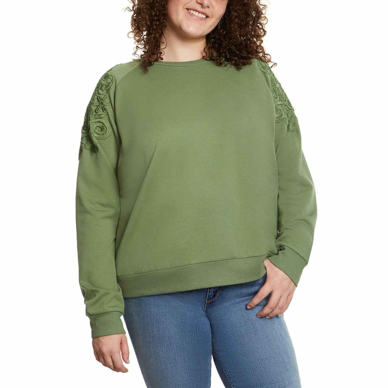 woman wearing a green pullover with lace on the sleeves