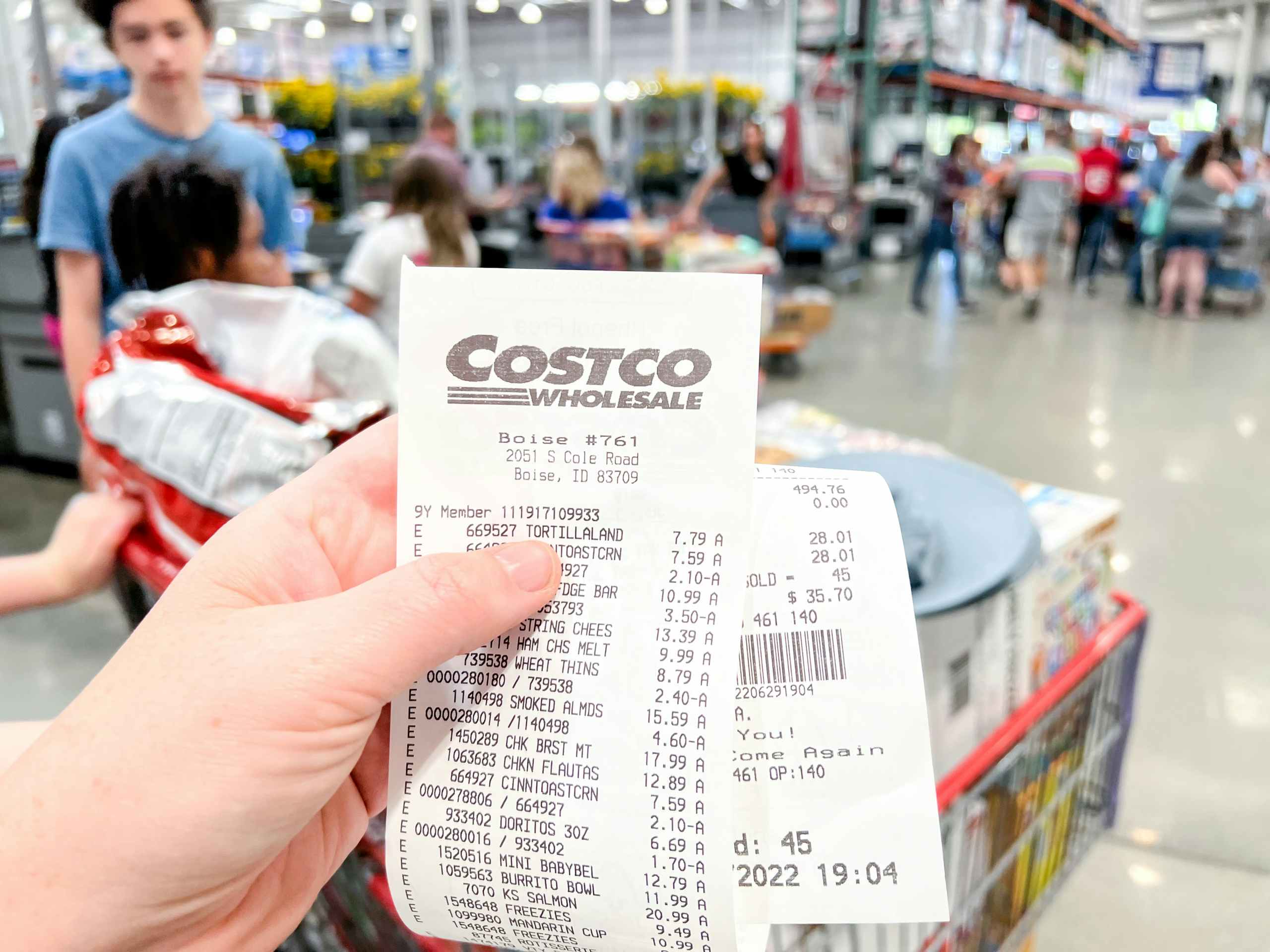 person's hand holding Costco receipt in store