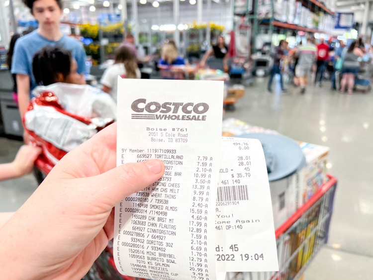 person's hand holding Costco receipt in store