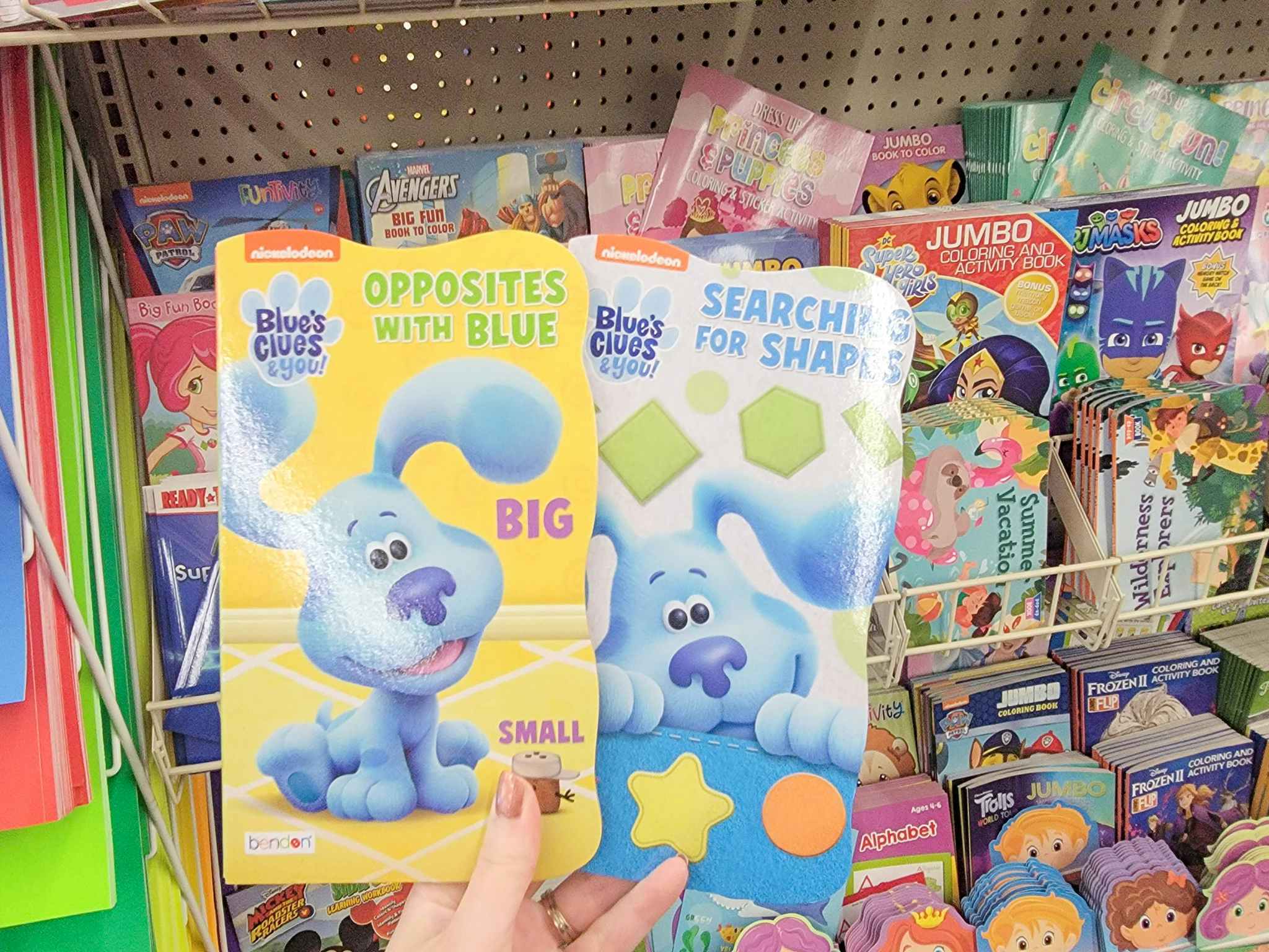 hand holding 2 blue's clues books: opposites and shapes