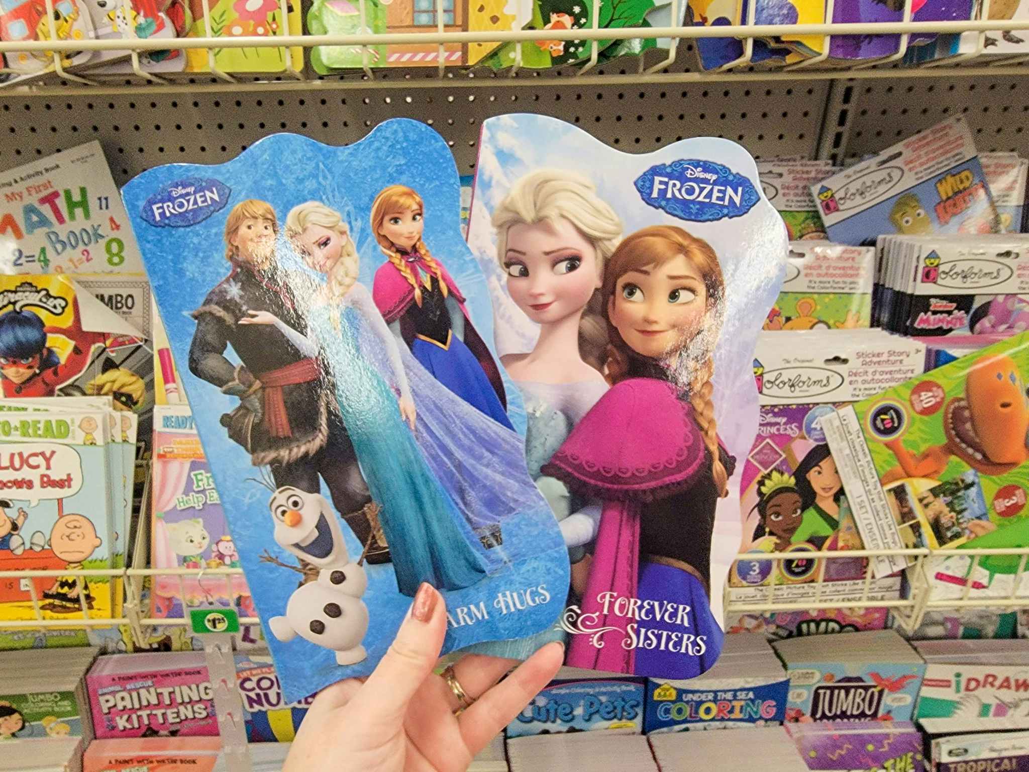 hand holding two disney frozen kids books