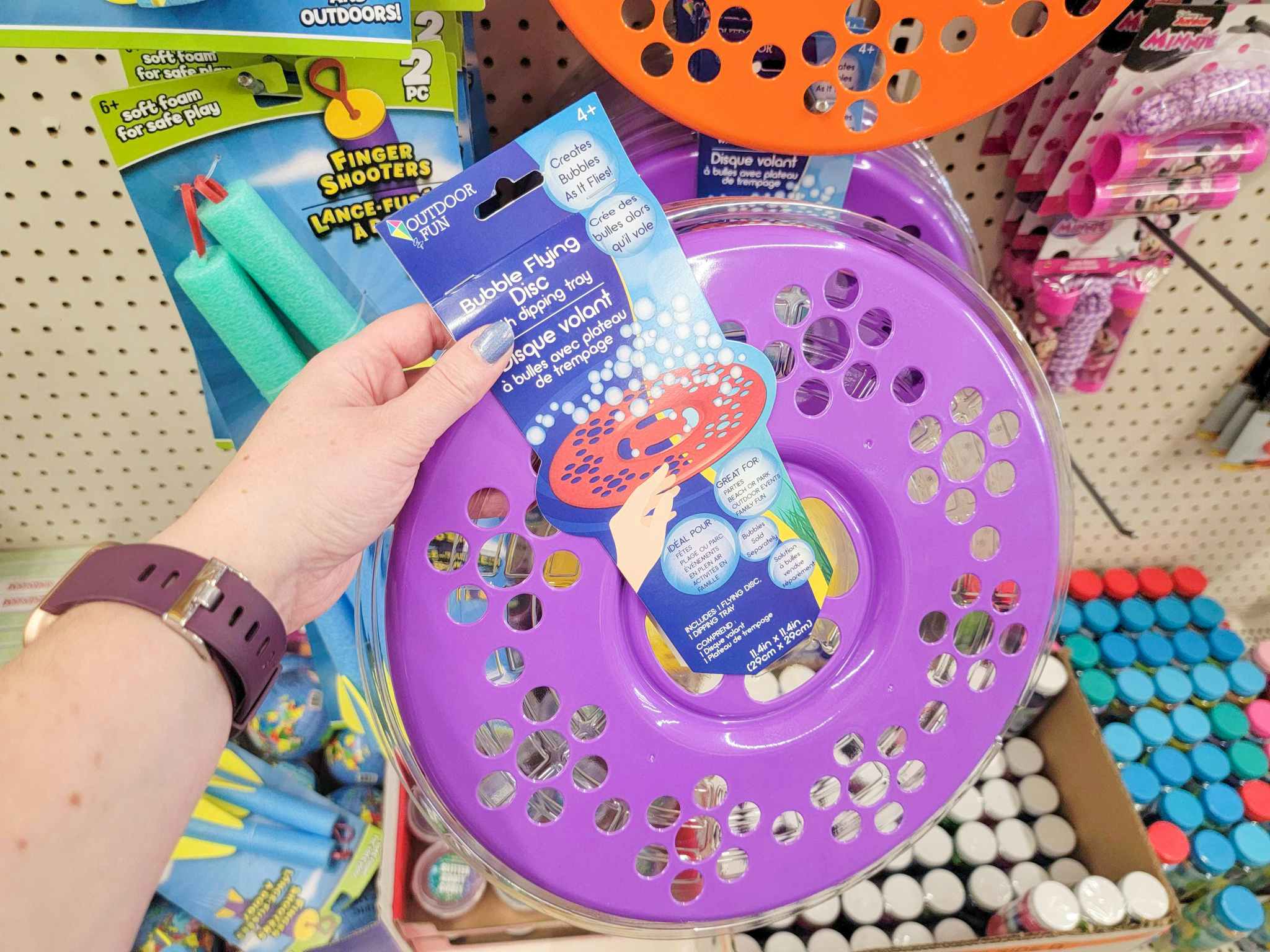hand holding a purple bubble flying disc