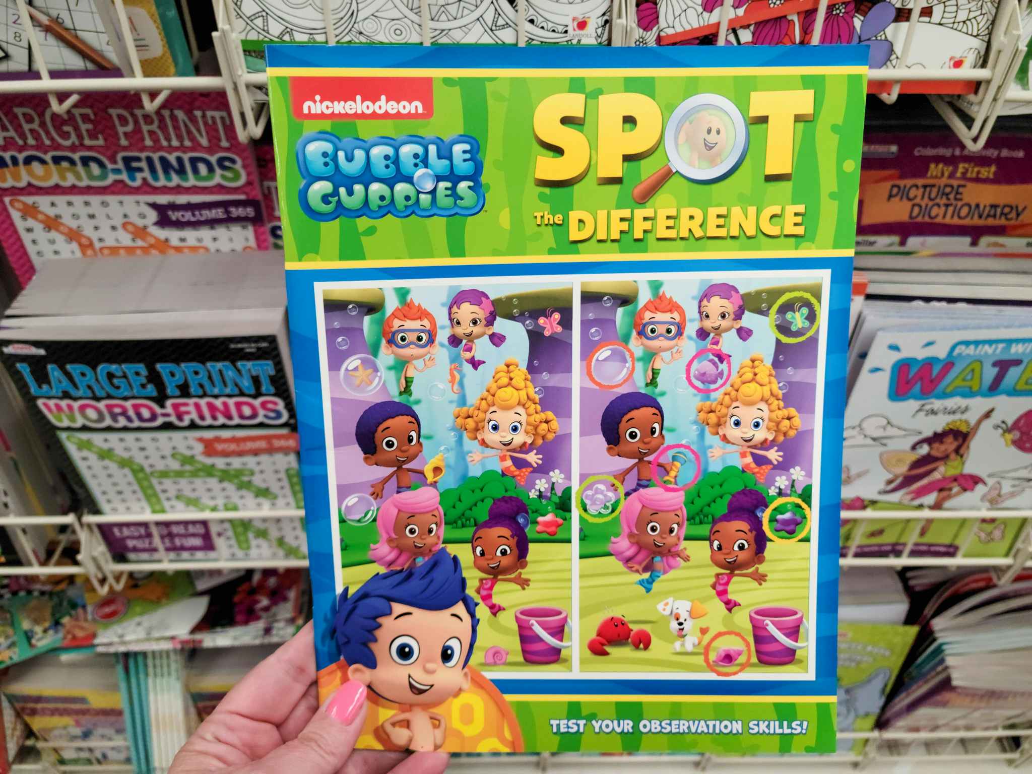 hand holding a bubble guppies activity book
