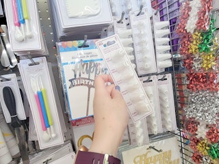 hand holding a pack of cake decorating tips