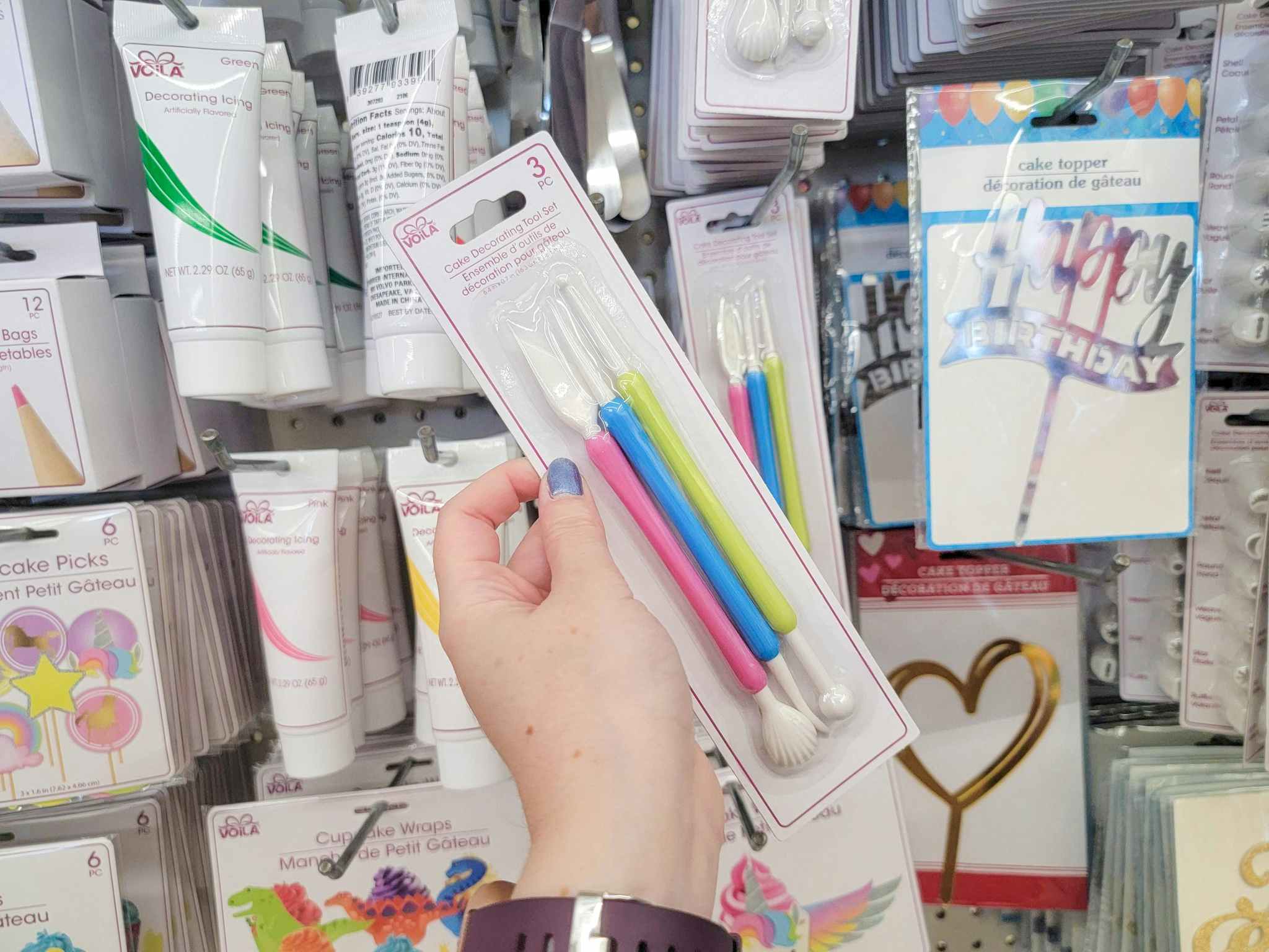 hand holding a pack of cake decorating tools