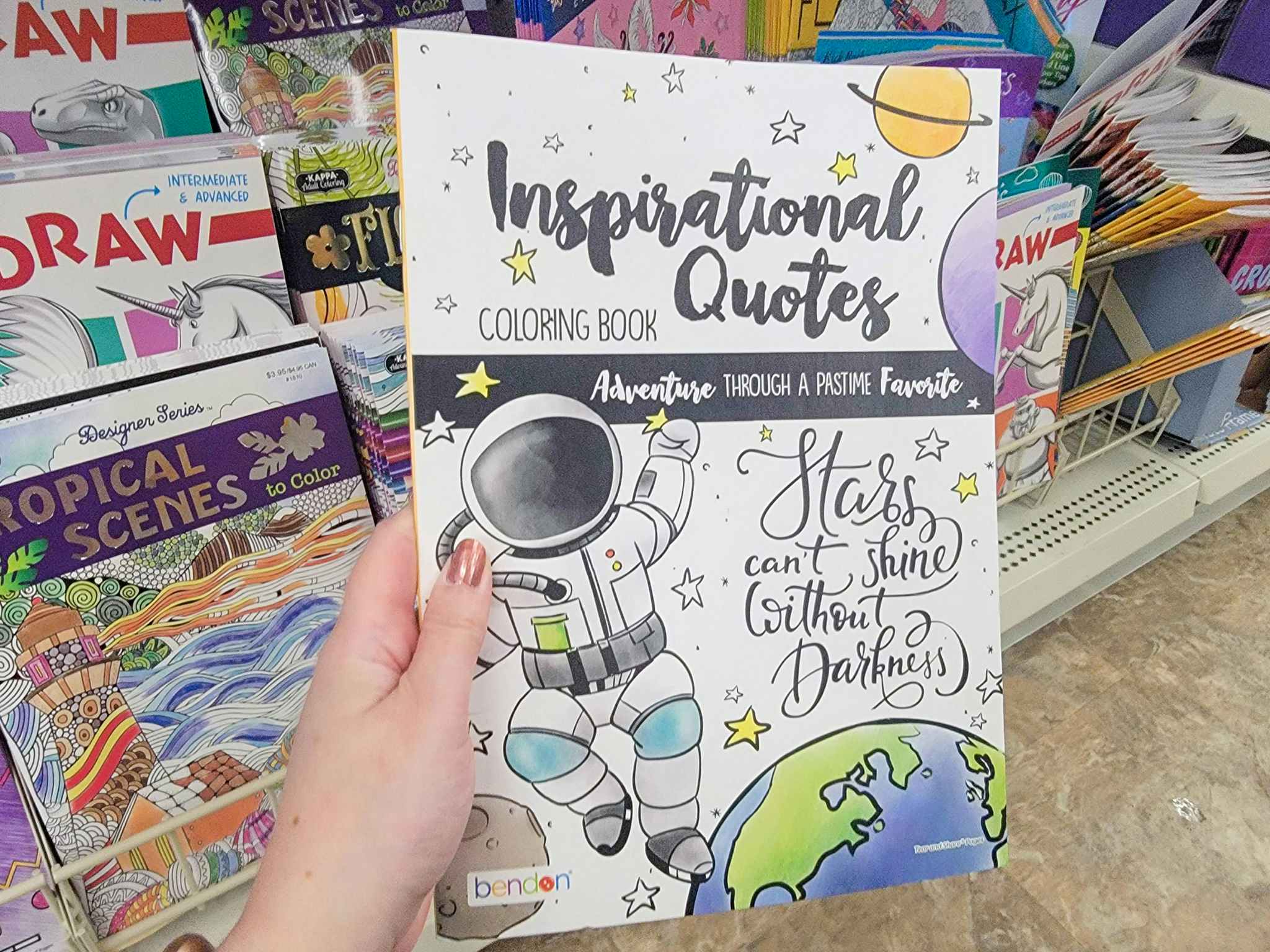 hand holding an inspirational quotes coloring book