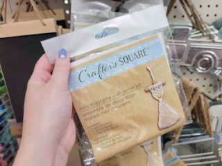 hand holding up a mini macrame wall decor kit