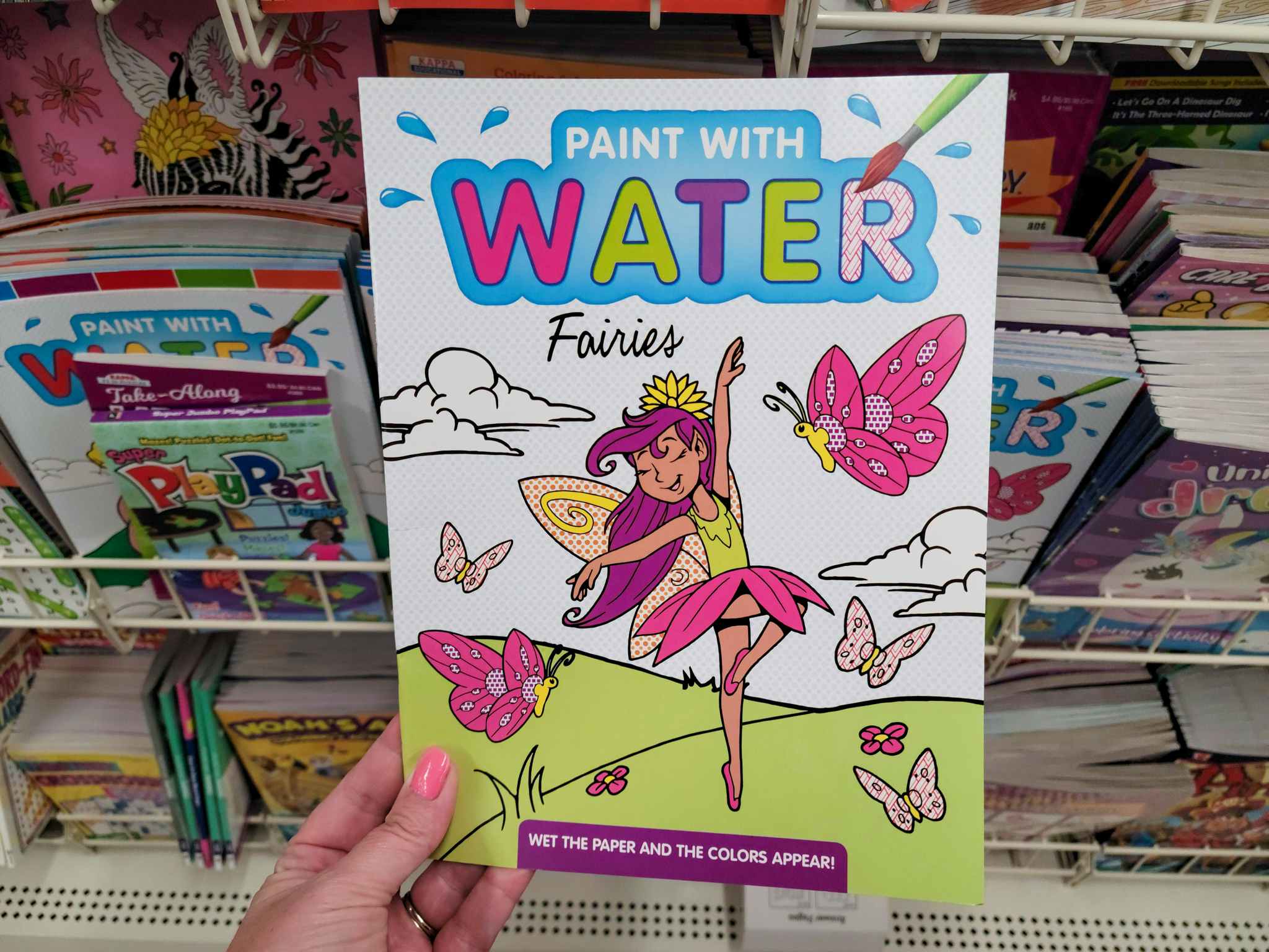 hand holding a paint with water fairies book