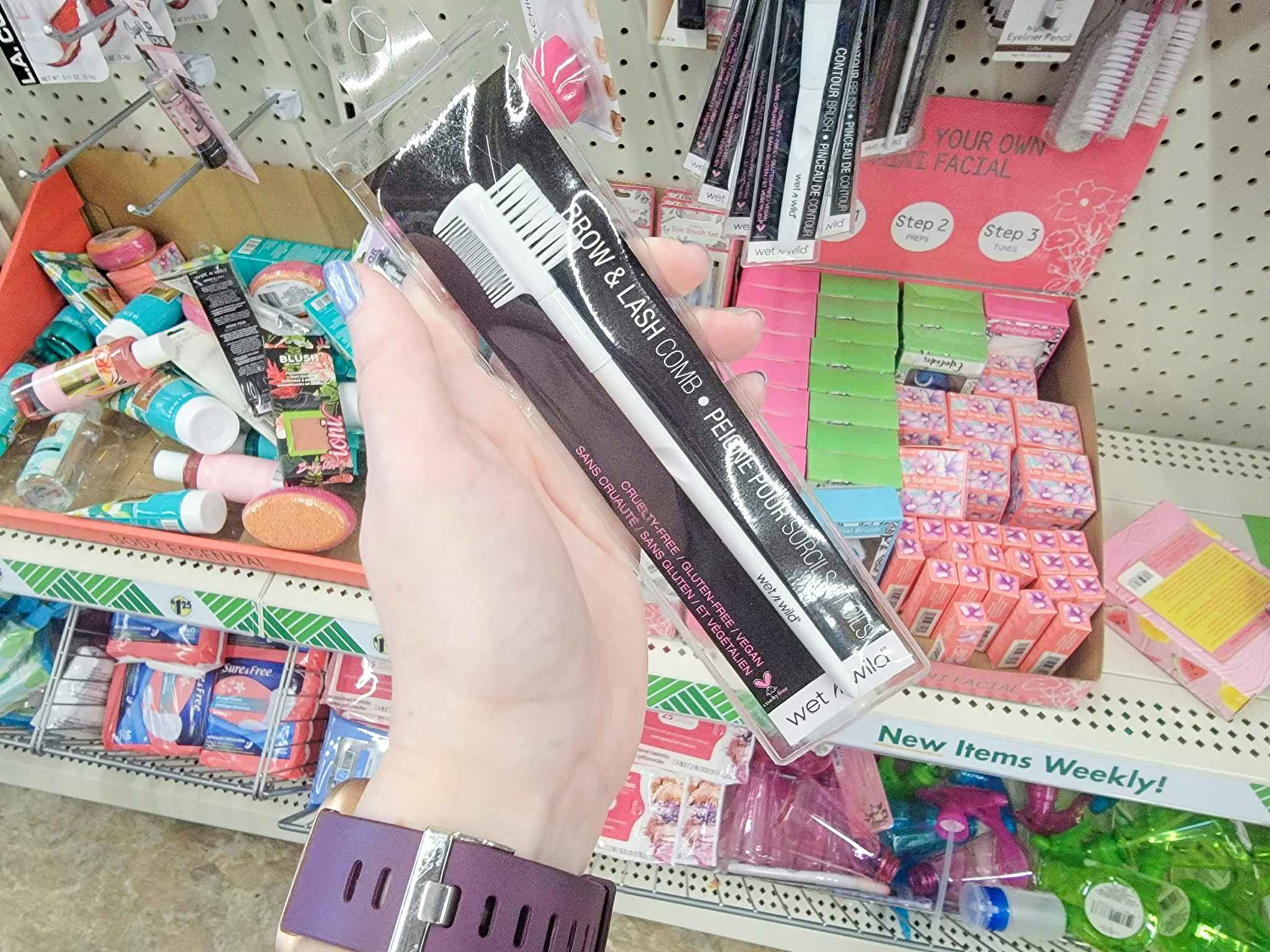 hand holding a wet n wild lash comb brush