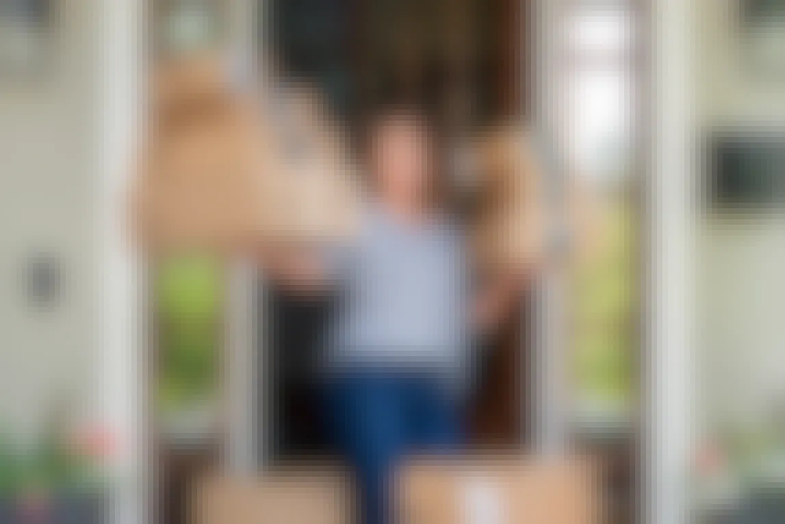 person surrounded by amazon delivery boxes on front porch
