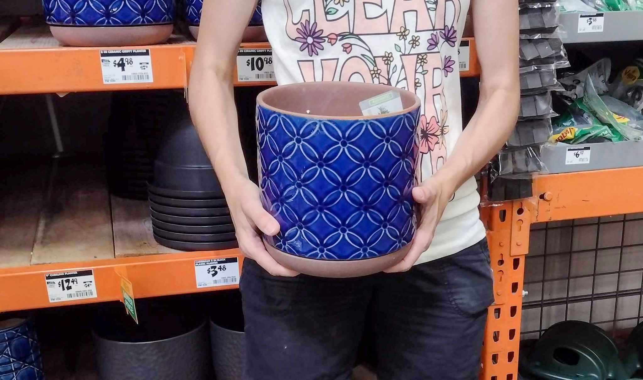 hands holding southern patio blue ceramic planter at home depot