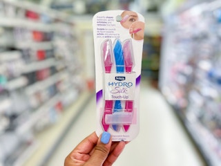 hand holding a pack of Schick Hydro Silk razors in aisle