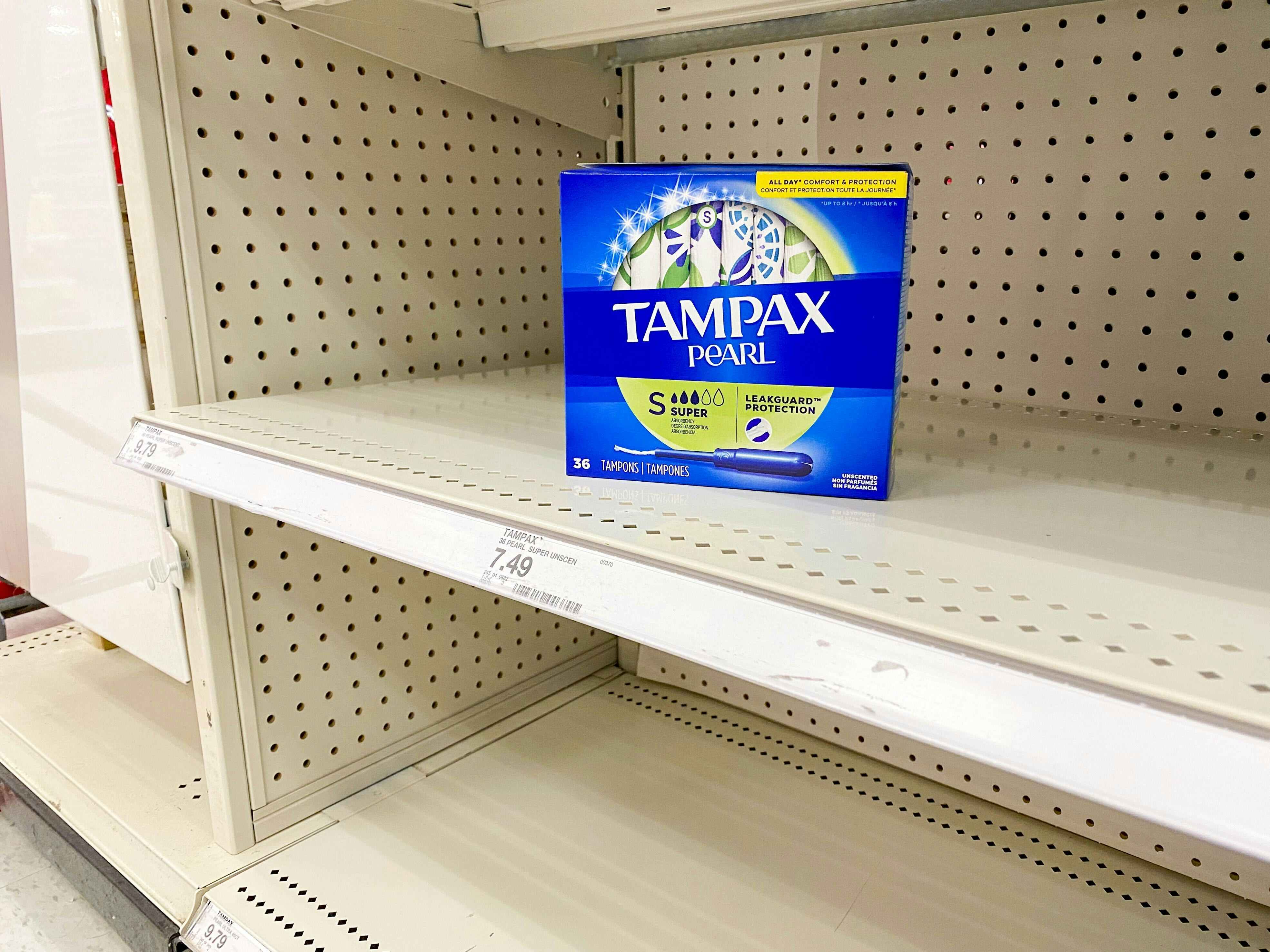 A single box of Tampax tampons sitting on an otherwise empty shelf in the Feminine Products aisle at Target.