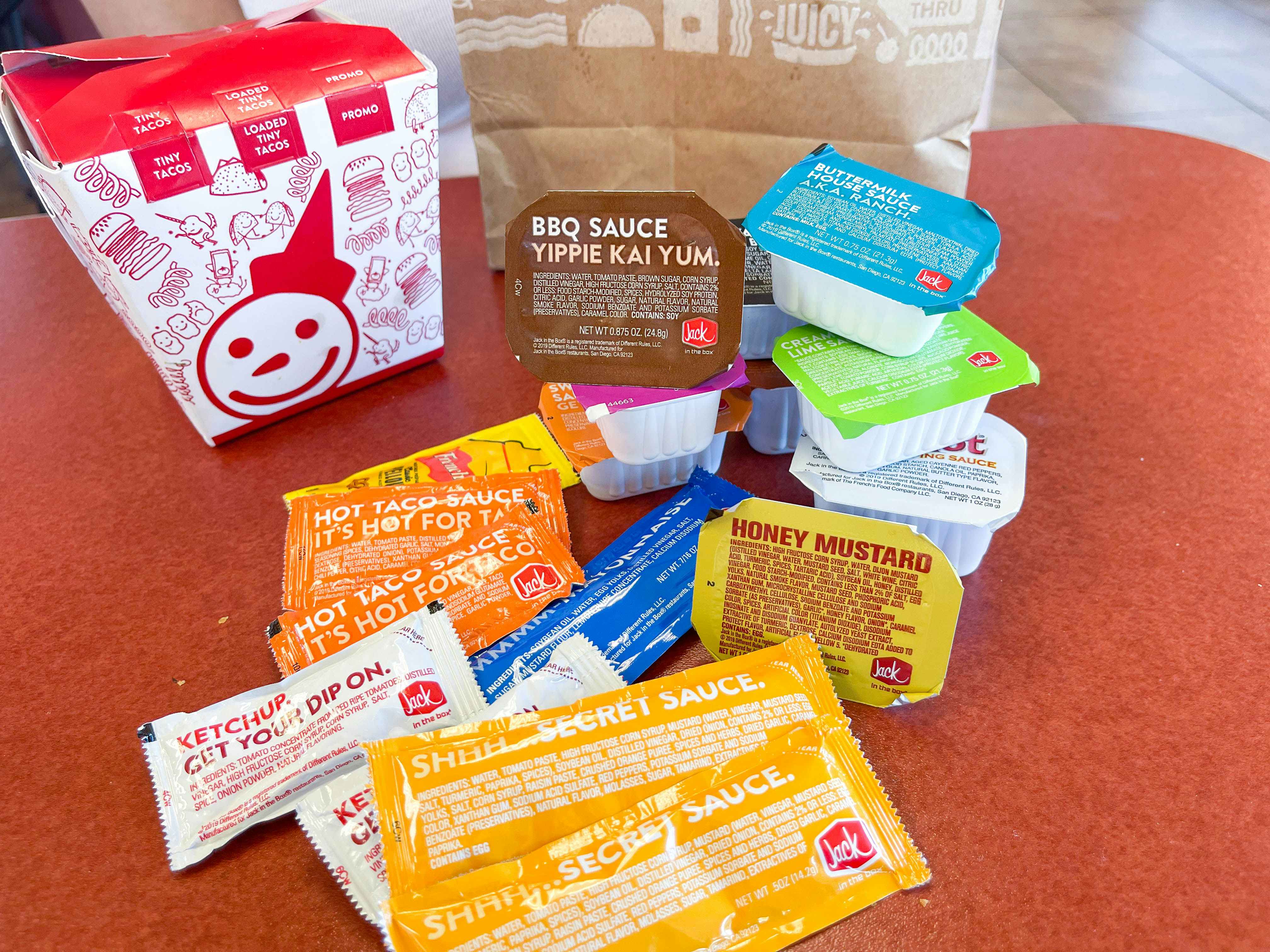 a lot of sauces and sauce packets on the table 