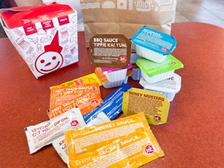 a lot of sauces and sauce packets on the table