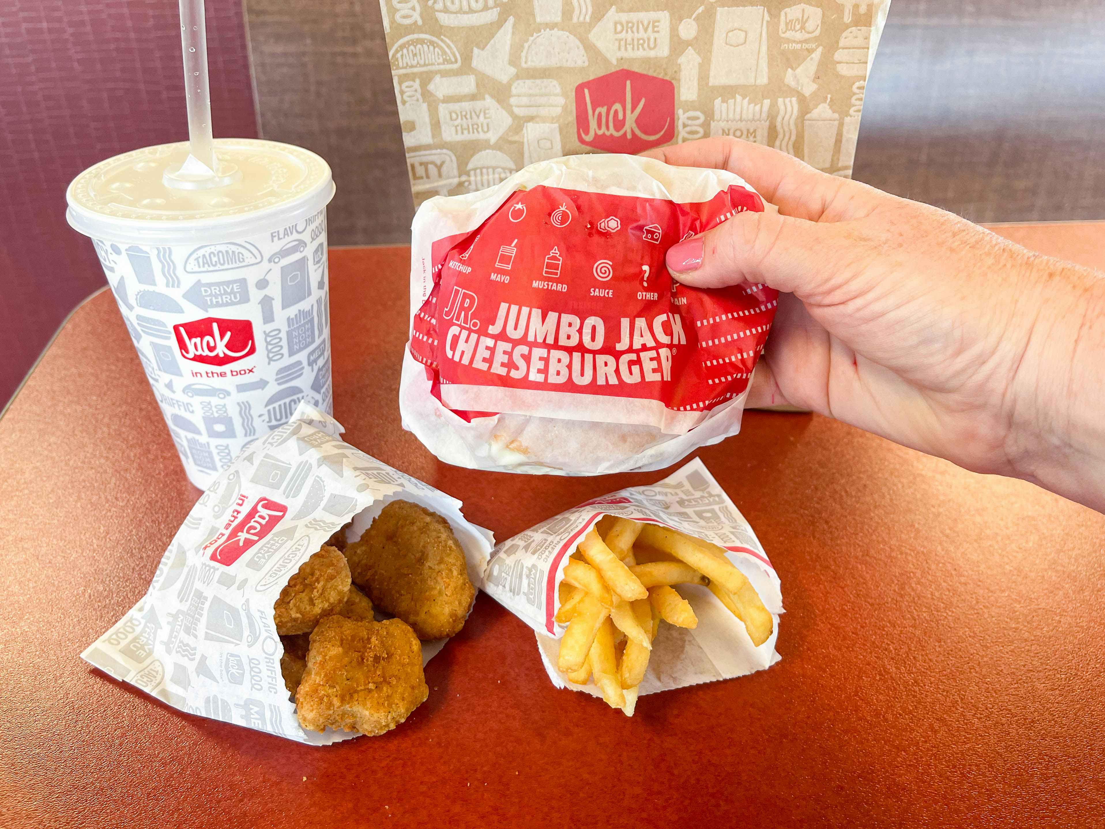 jack in the box value menu items on table with jr jack burger being held up