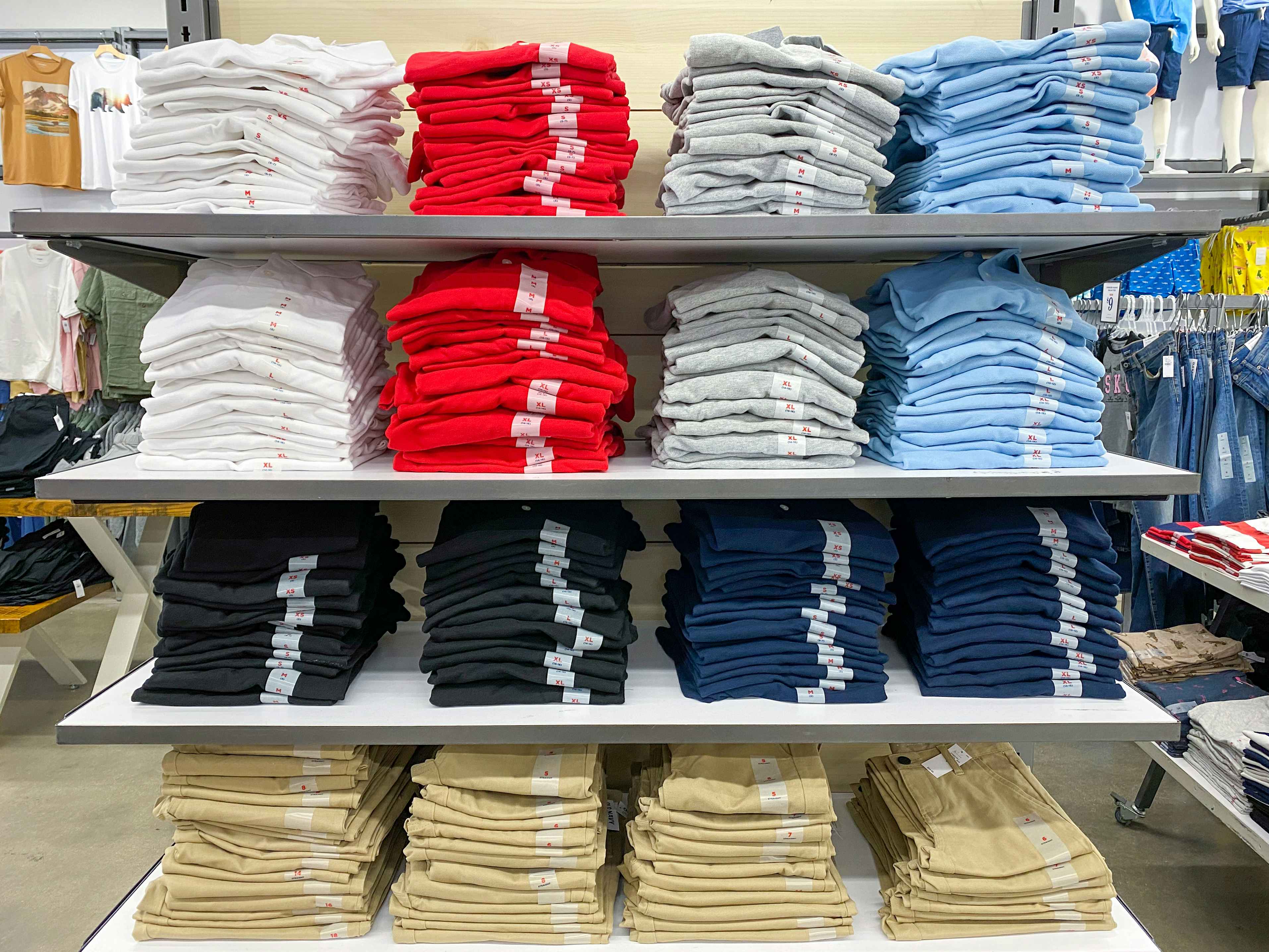 Stacks of children's school uniform polo shirts and pants on shelves at Old Navy.