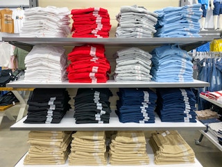 Stacks of children's school uniform polo shirts and pants on shelves at Old Navy.
