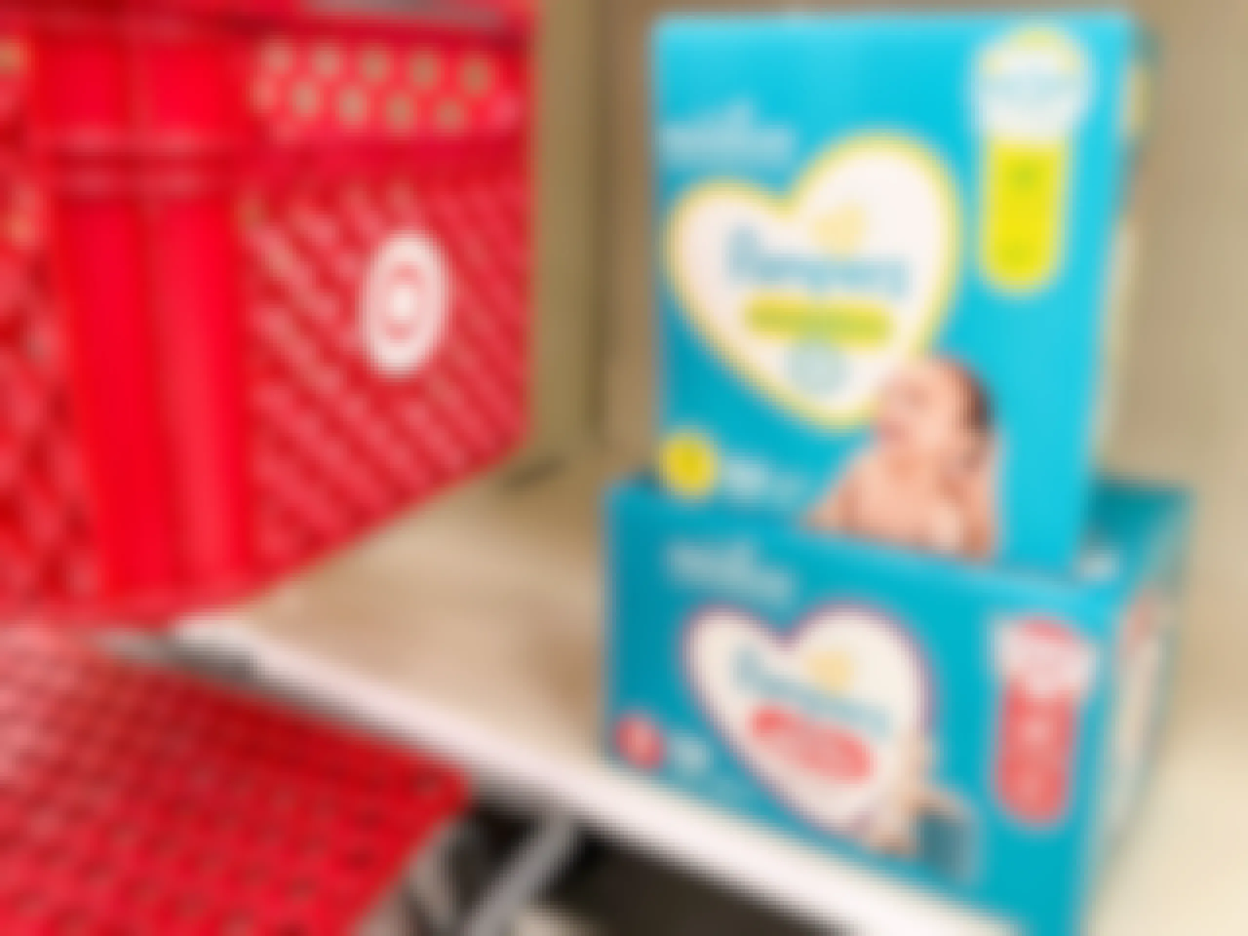 Two boxes of Pampers diapers on store shelf next to Target shopping cart