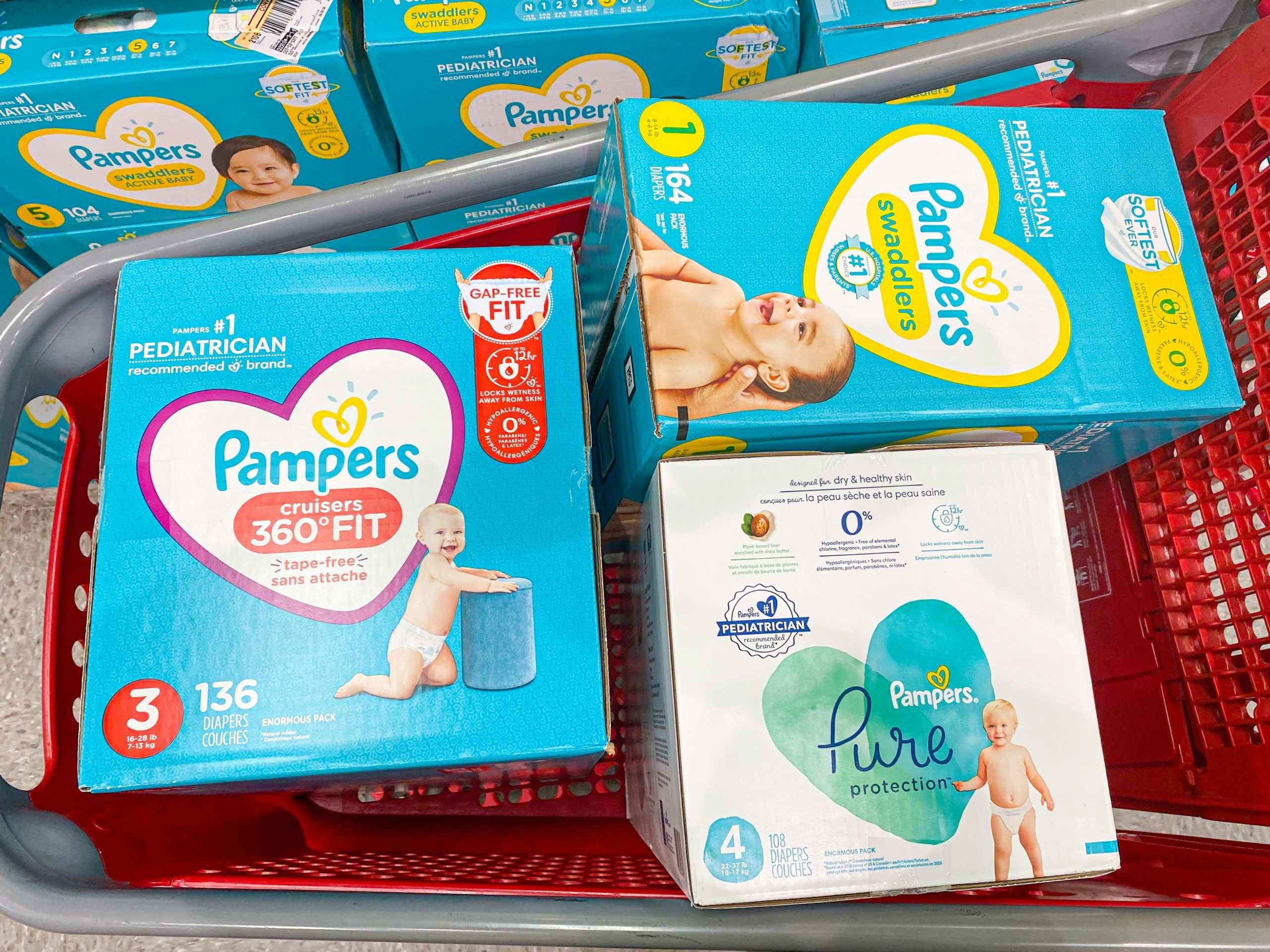 Three boxes of Pampers diapers stacked in a Target shopping cart