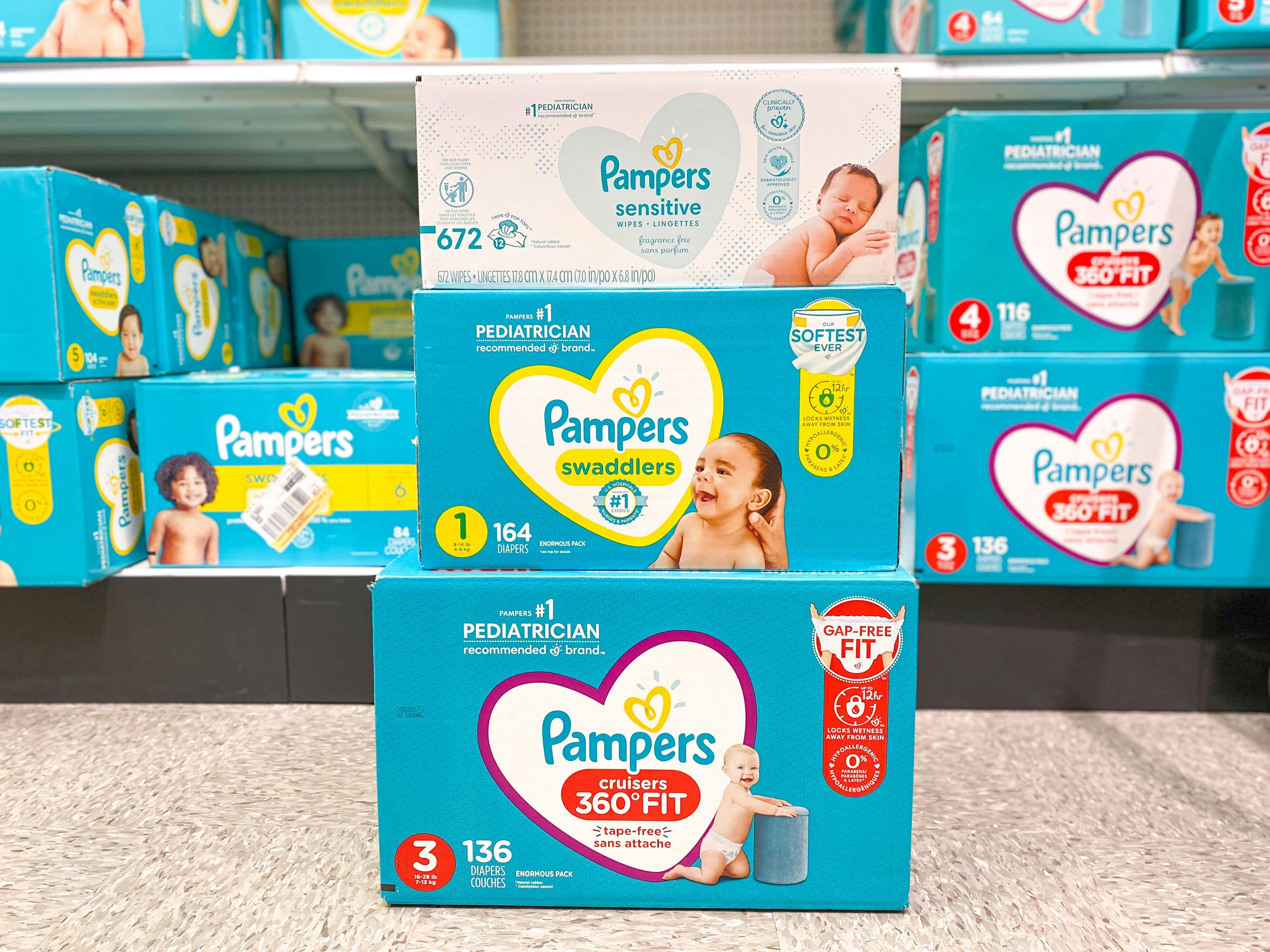 three boxes of Pampers stacked in a store aisle