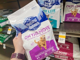 hand holding a bag of natural balance dog food