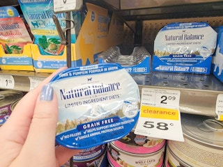 hand holding a container of natural balance tuna and pumpkin cat food