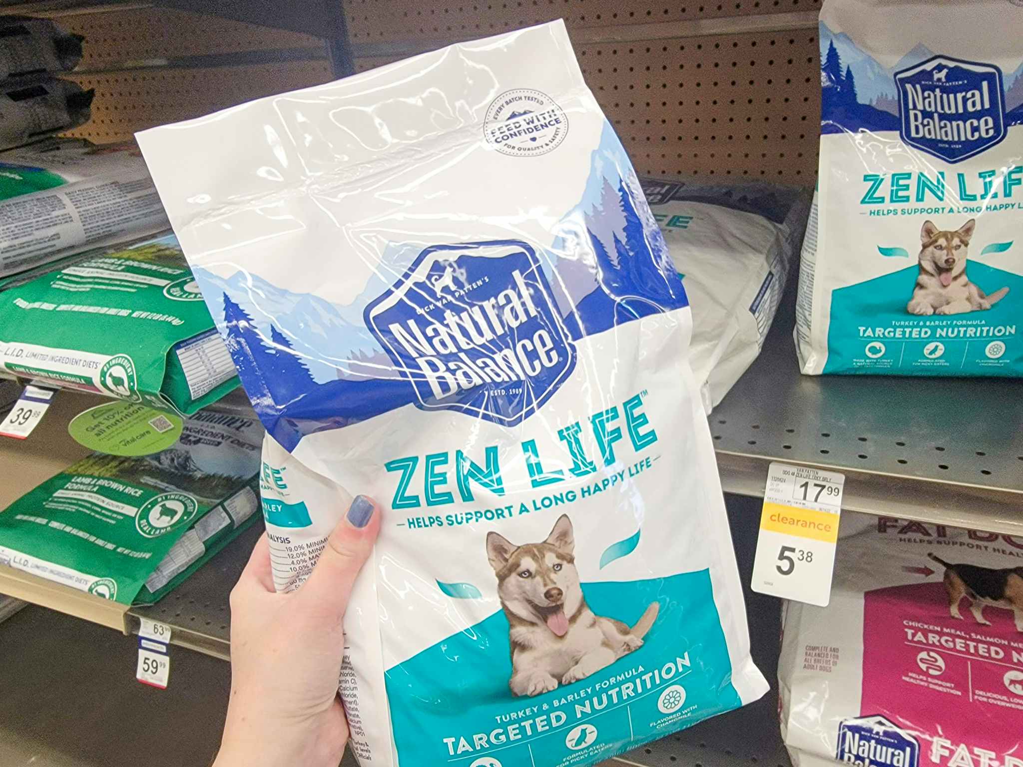 hand holding a small bag of natural balance dog food