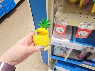 hand holding a pineapple aquarium decor piece