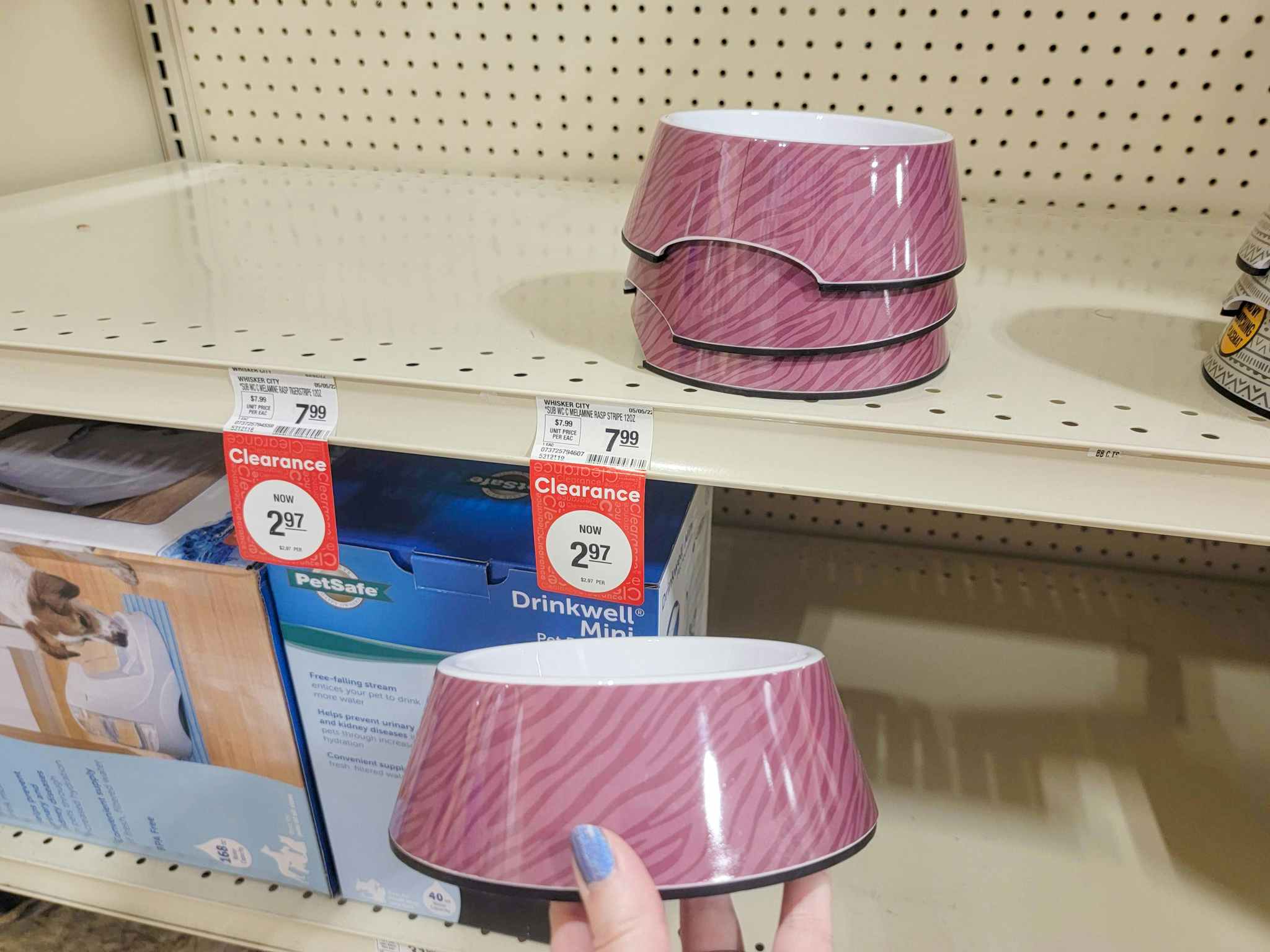hand holding a purple pet food bowl