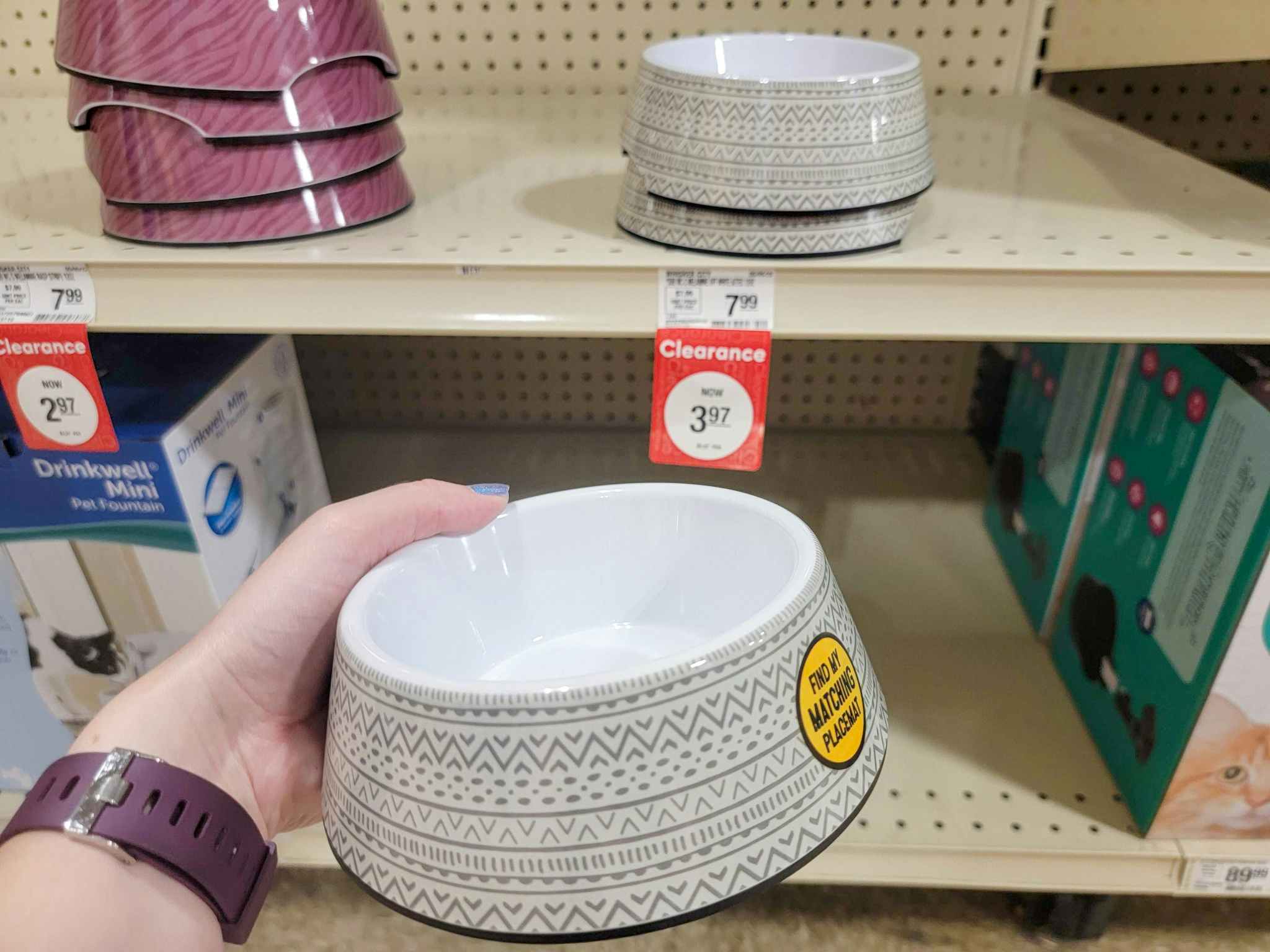 hand holding a grey and white pet food bowl by the clearance tag