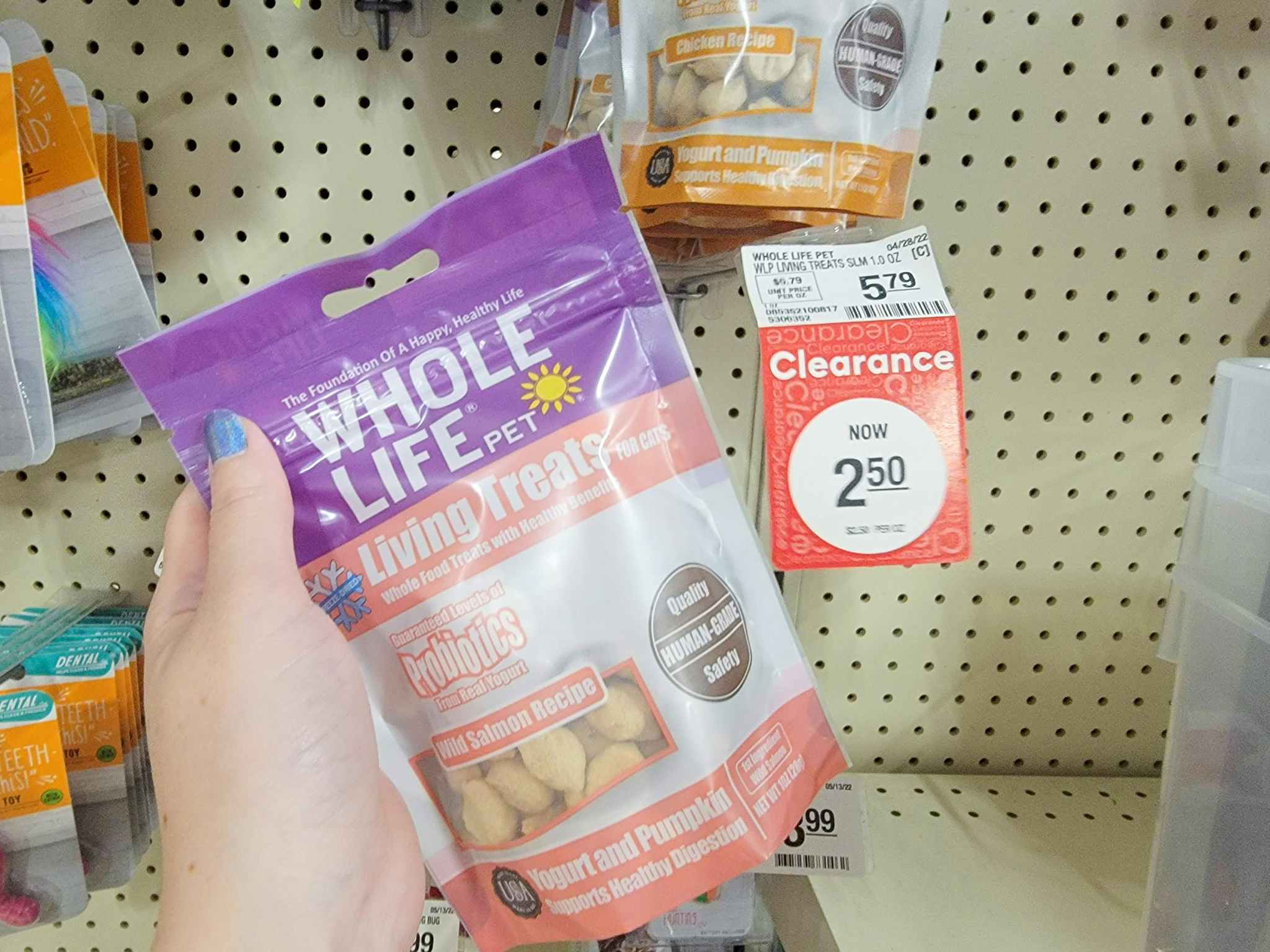 hand holding up a bag of cat treats by the clearance tag