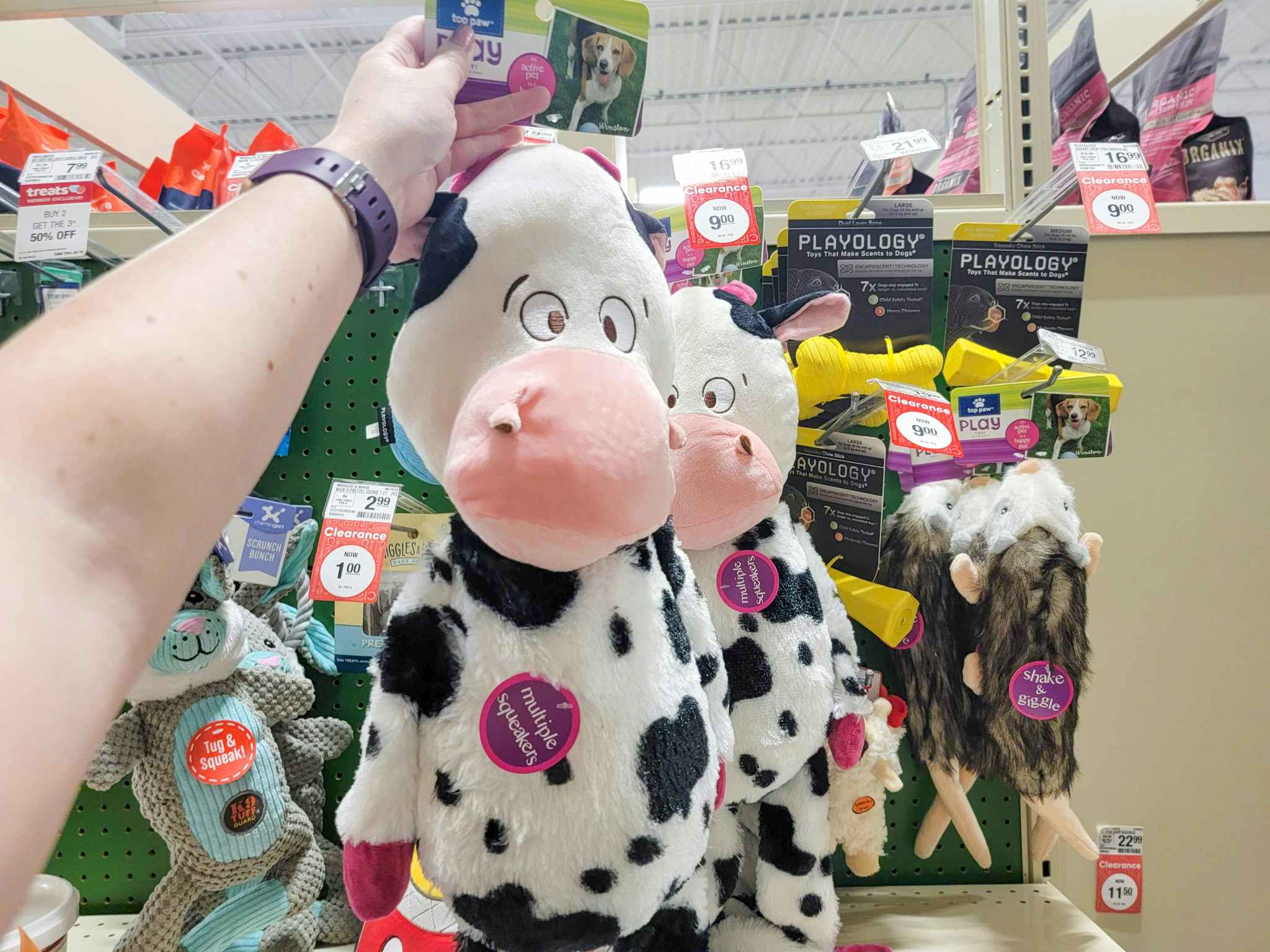 hand holding a cow dog toy