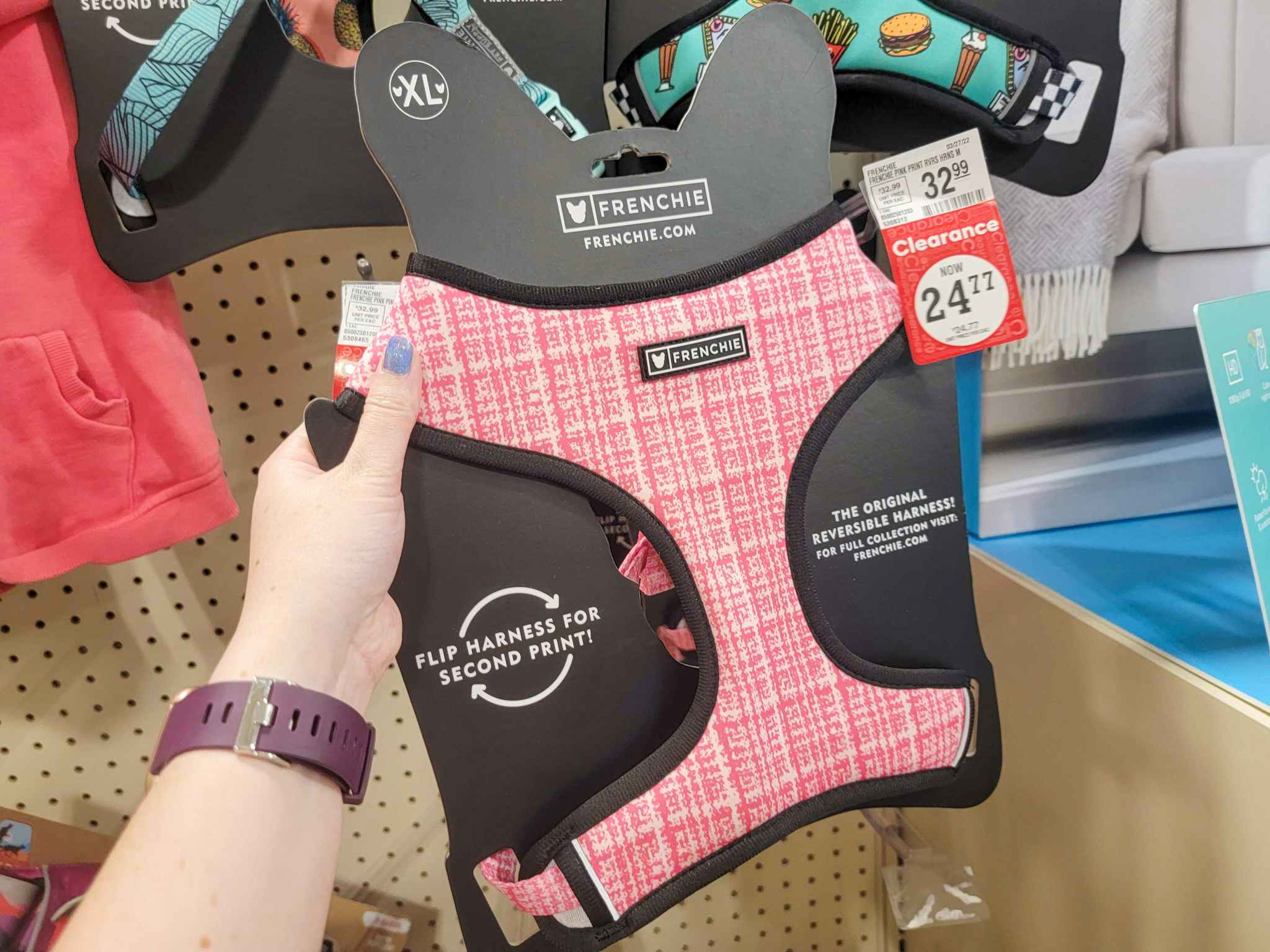 hand holding a pink dog harness