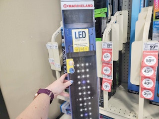 hand holding a marineland led light strip for aquariums