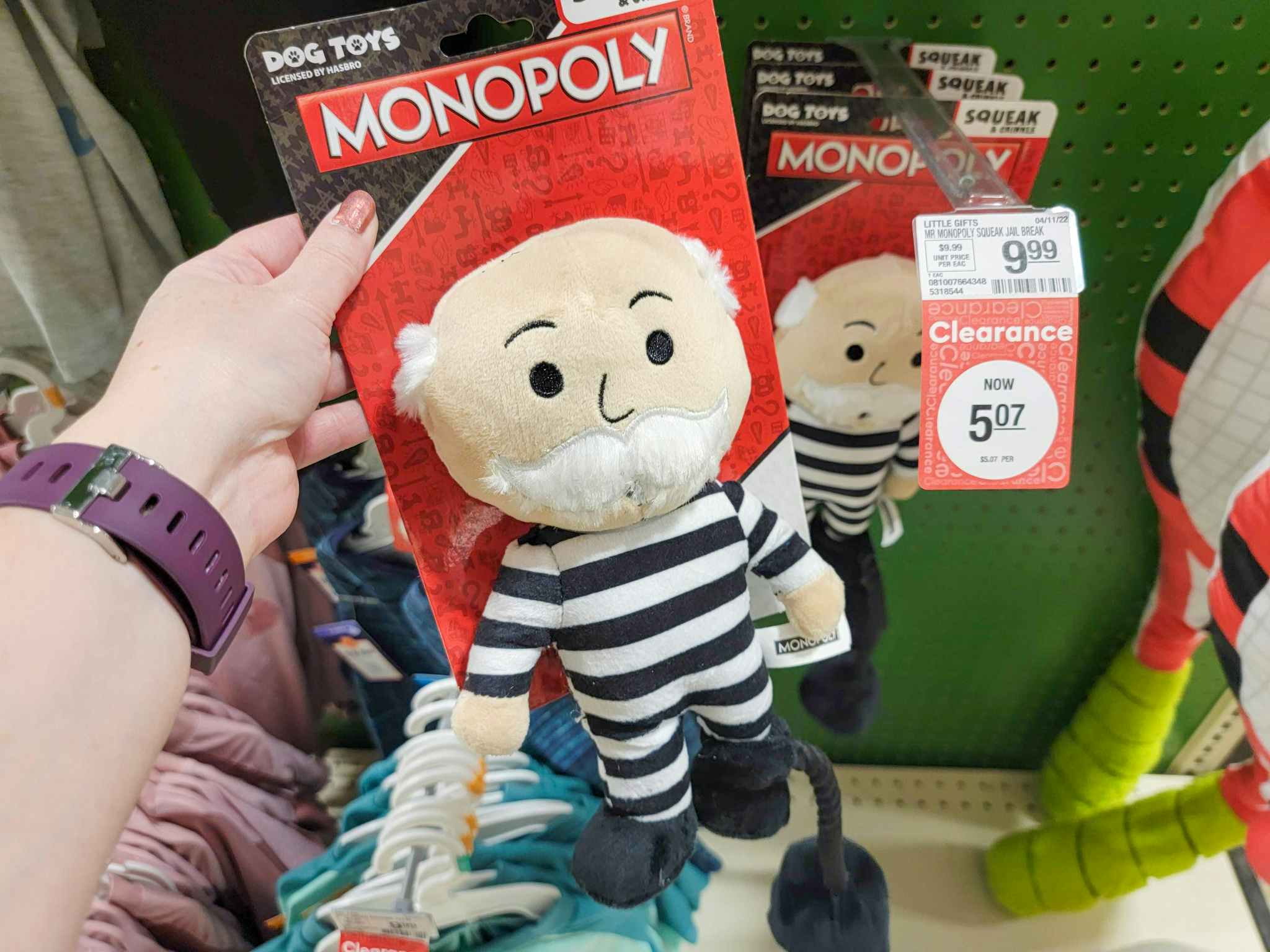 hand holding a monopoly man dog toy