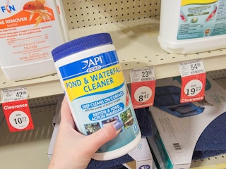 hand holding a bottle of pond and waterfall cleaner