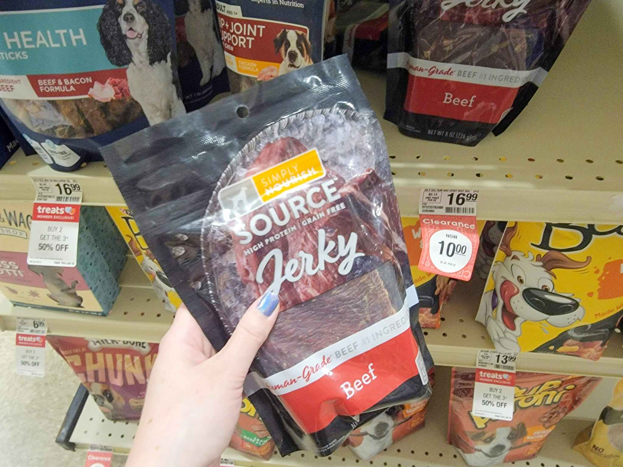 hand holding a bag of jerky dog treats