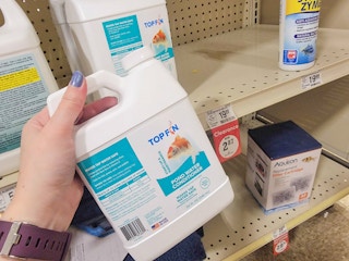 hand holding a bottle of pond water conditioner